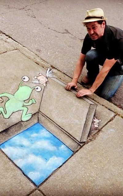 Man with drawing on the sidewalk. 