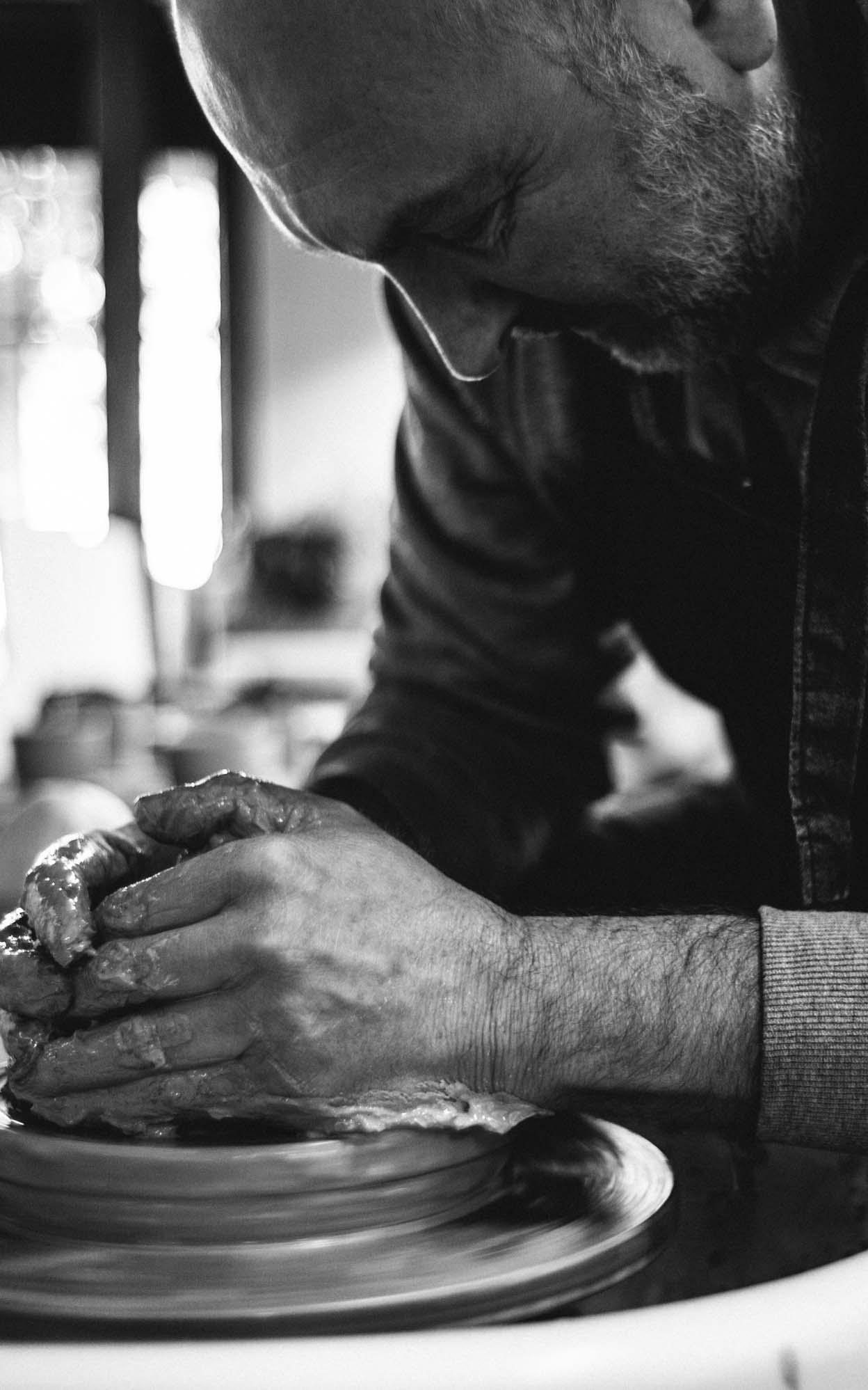 Ceramicist working on his pottery wheel.