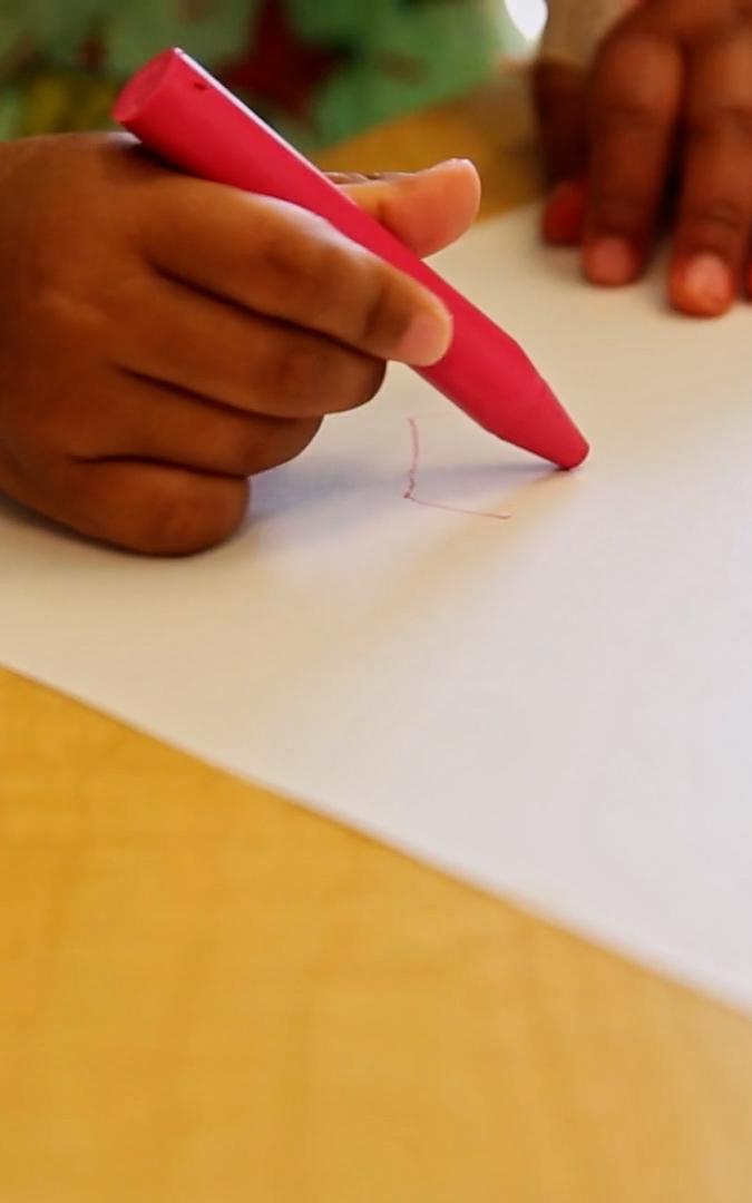 Beautiful News-Child holding a crayon.