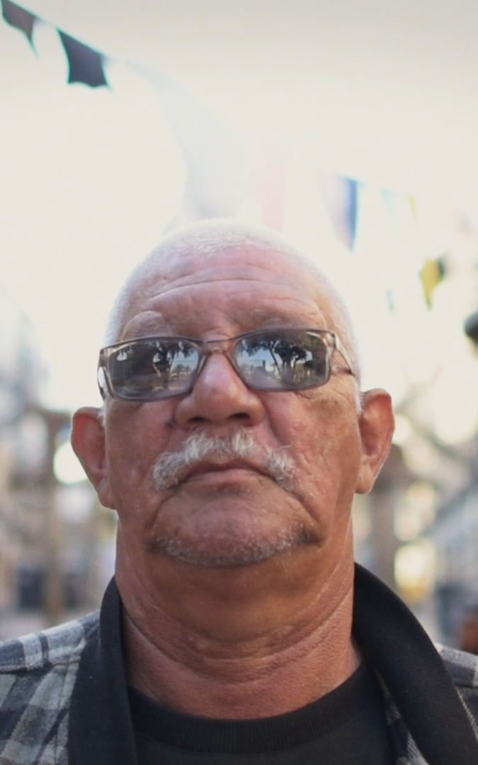 Old coloured man standing in between blocks of flats.