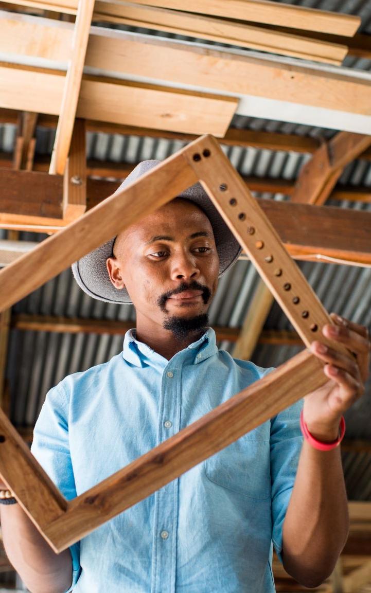 Black man holding wooden frame.