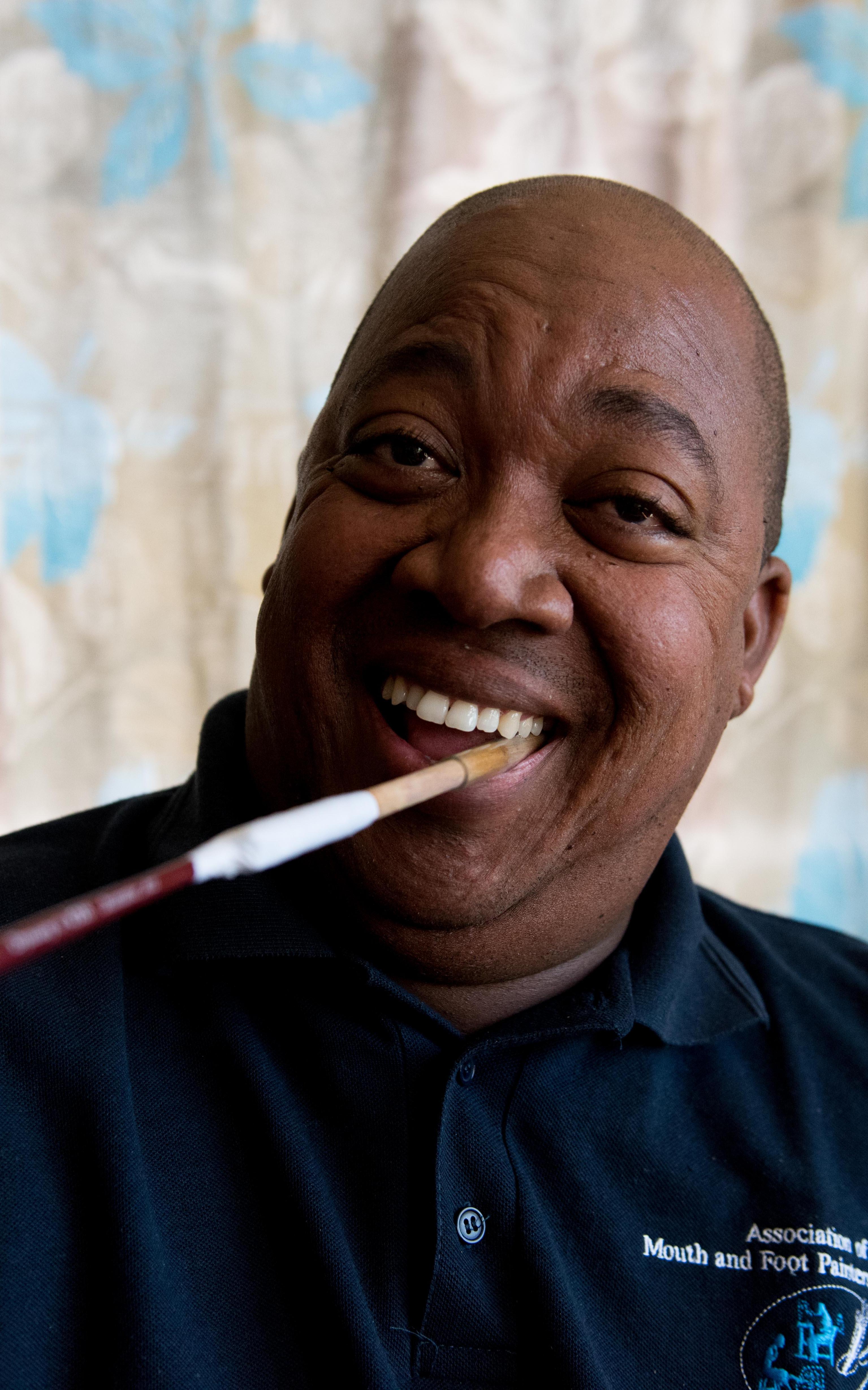 Man with paintbrush in his mouth