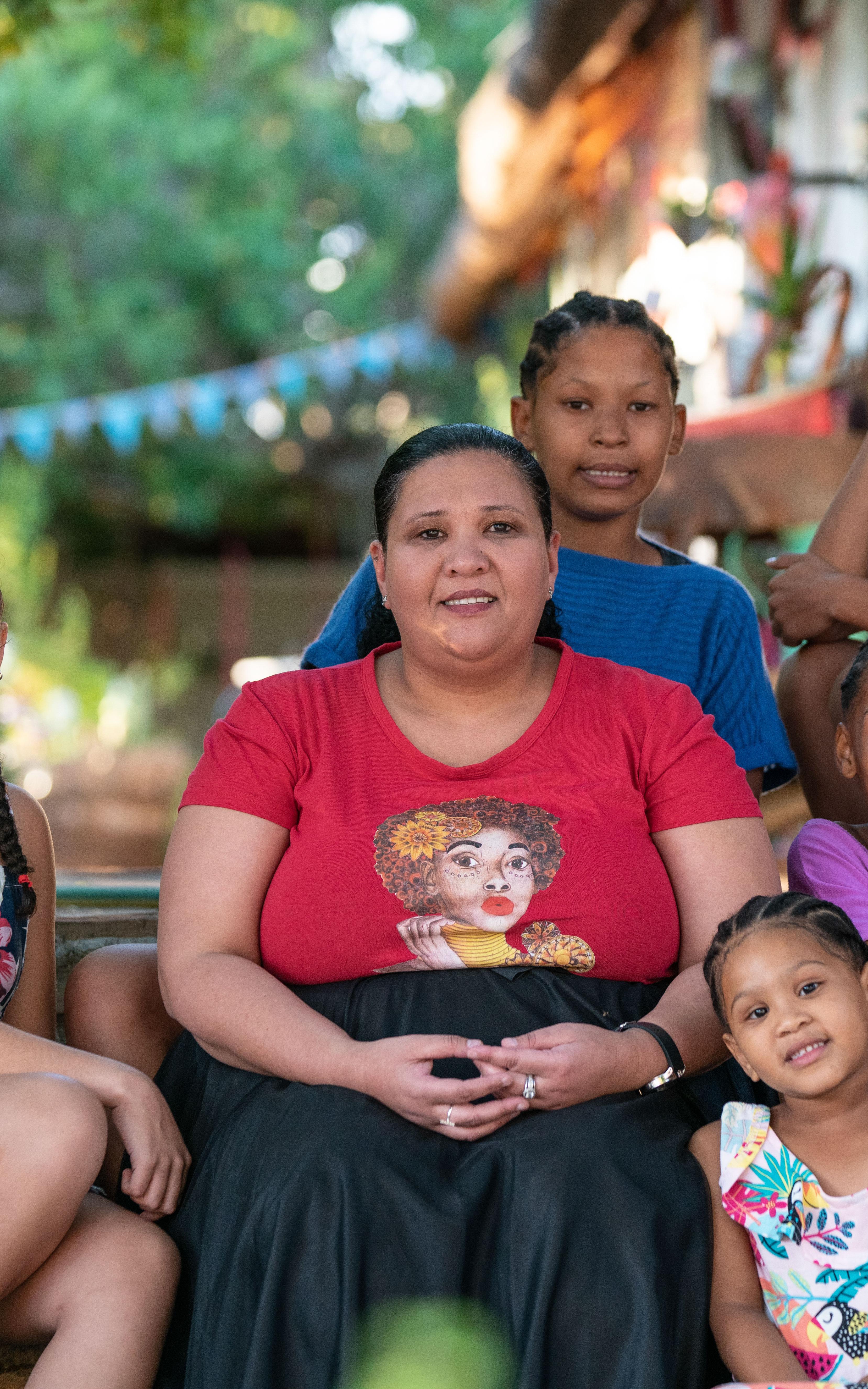 Women sitting with young girls.