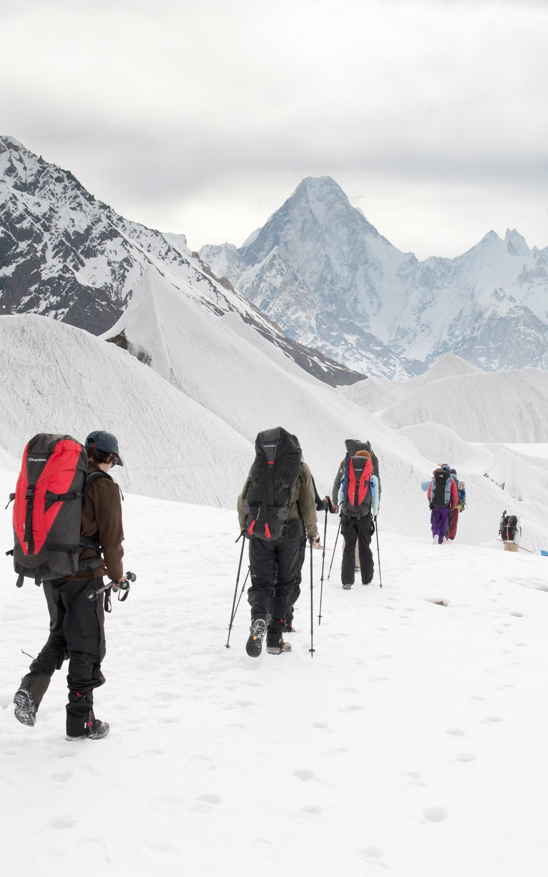 Mountaineers walking over snowy plains.