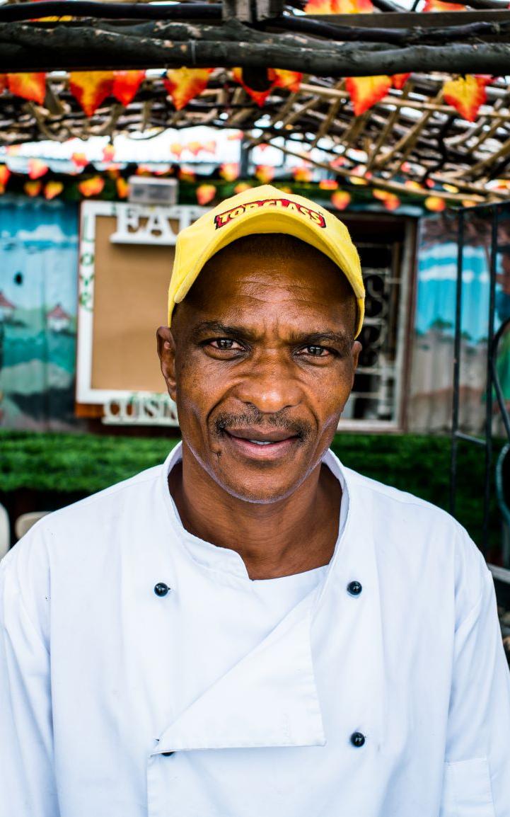 Black man smiling into camera.