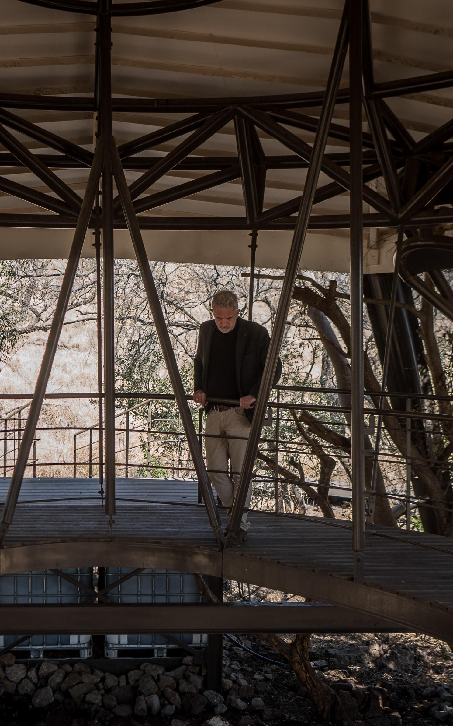 Man looks down while standing in a wooden structure
