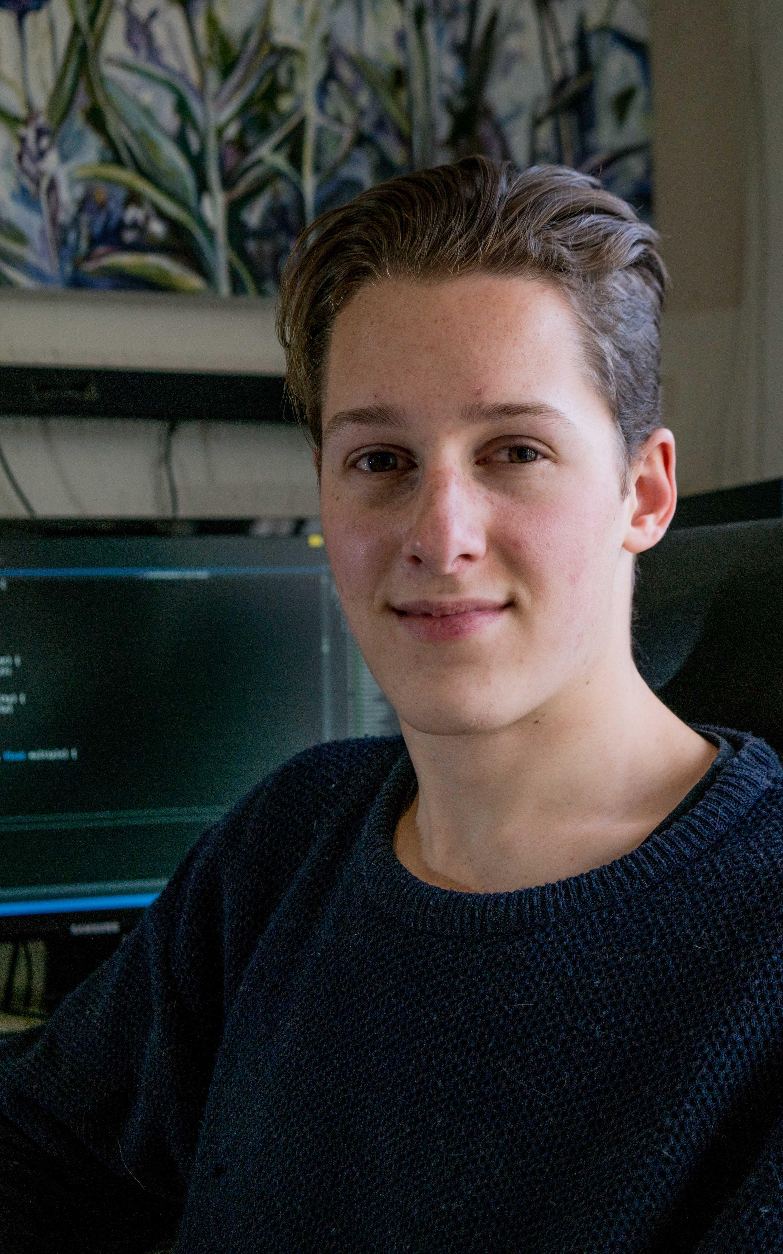 Teenager smiling in front of computer