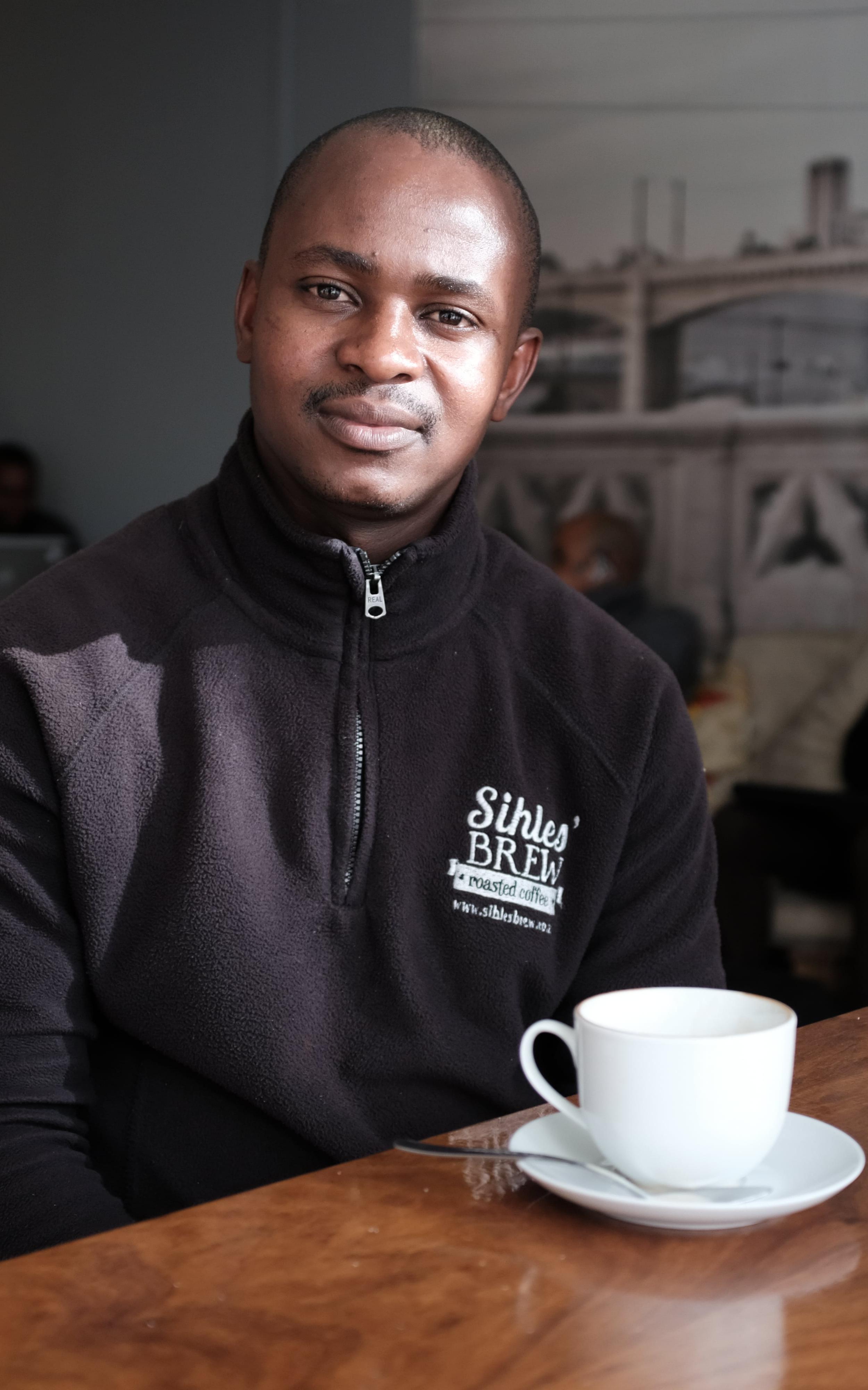 Black man smiling with coffee cup