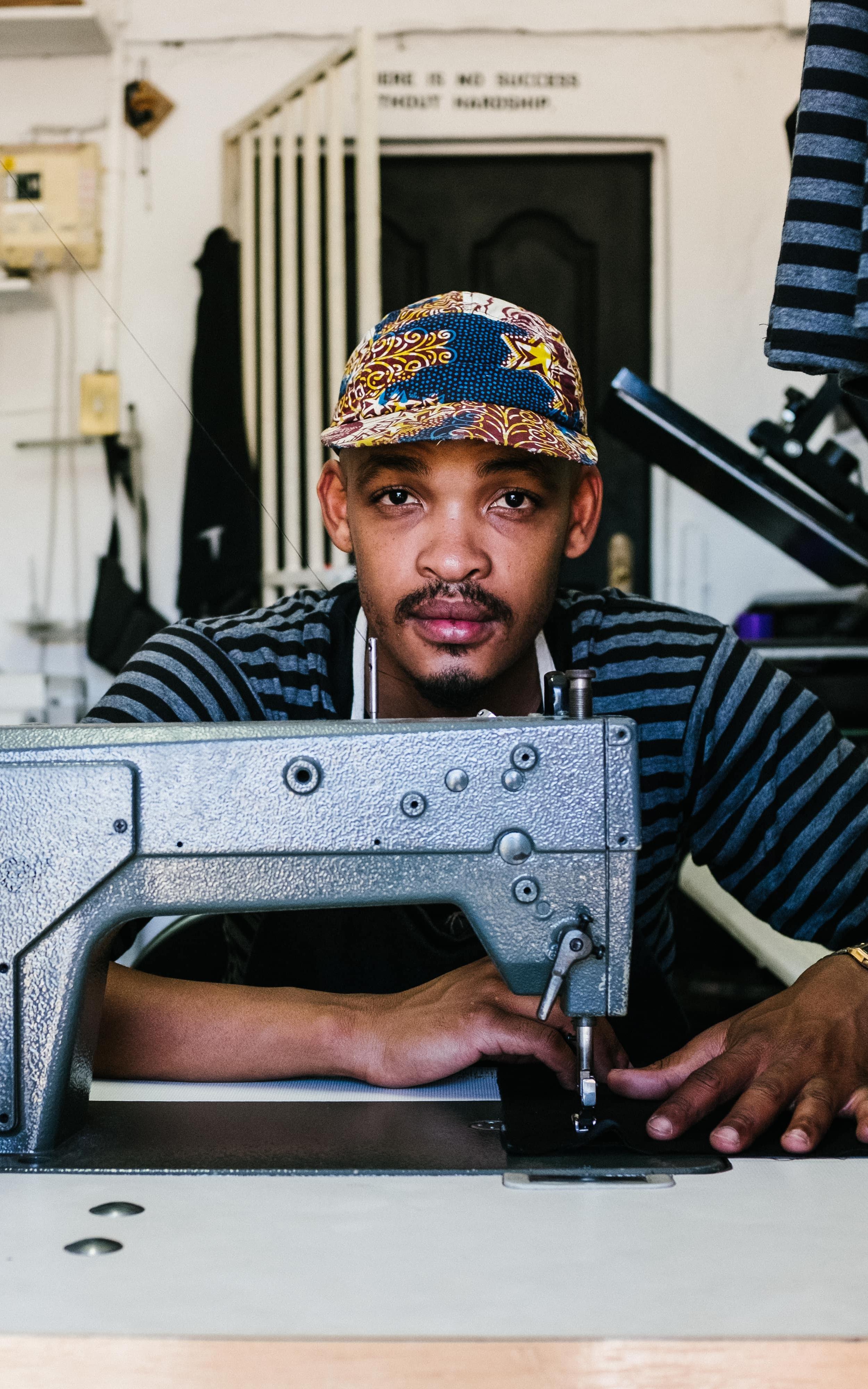 Fashion designer sitting behind his sewing machine.
