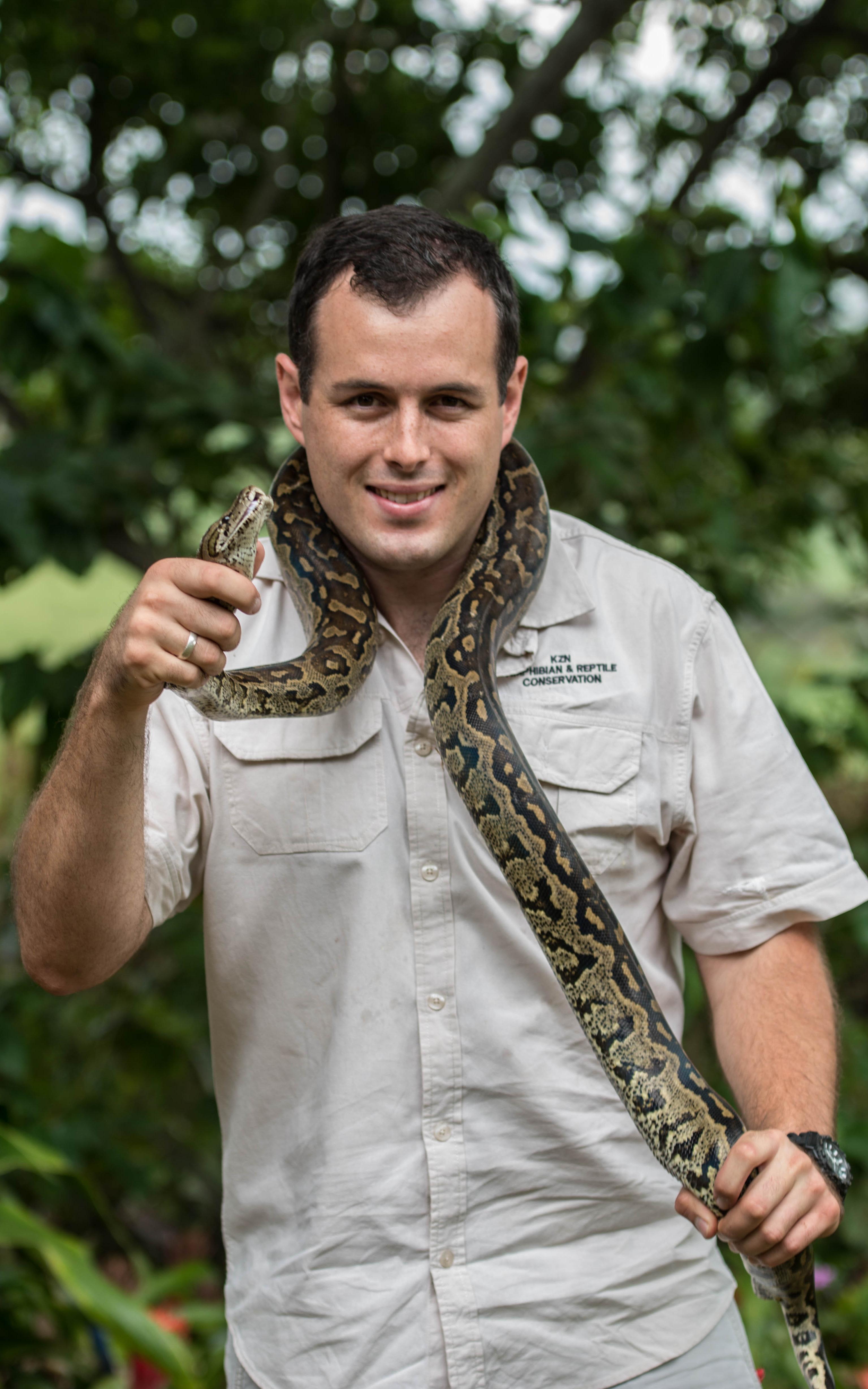 Man smiling with a snake around his shoulders