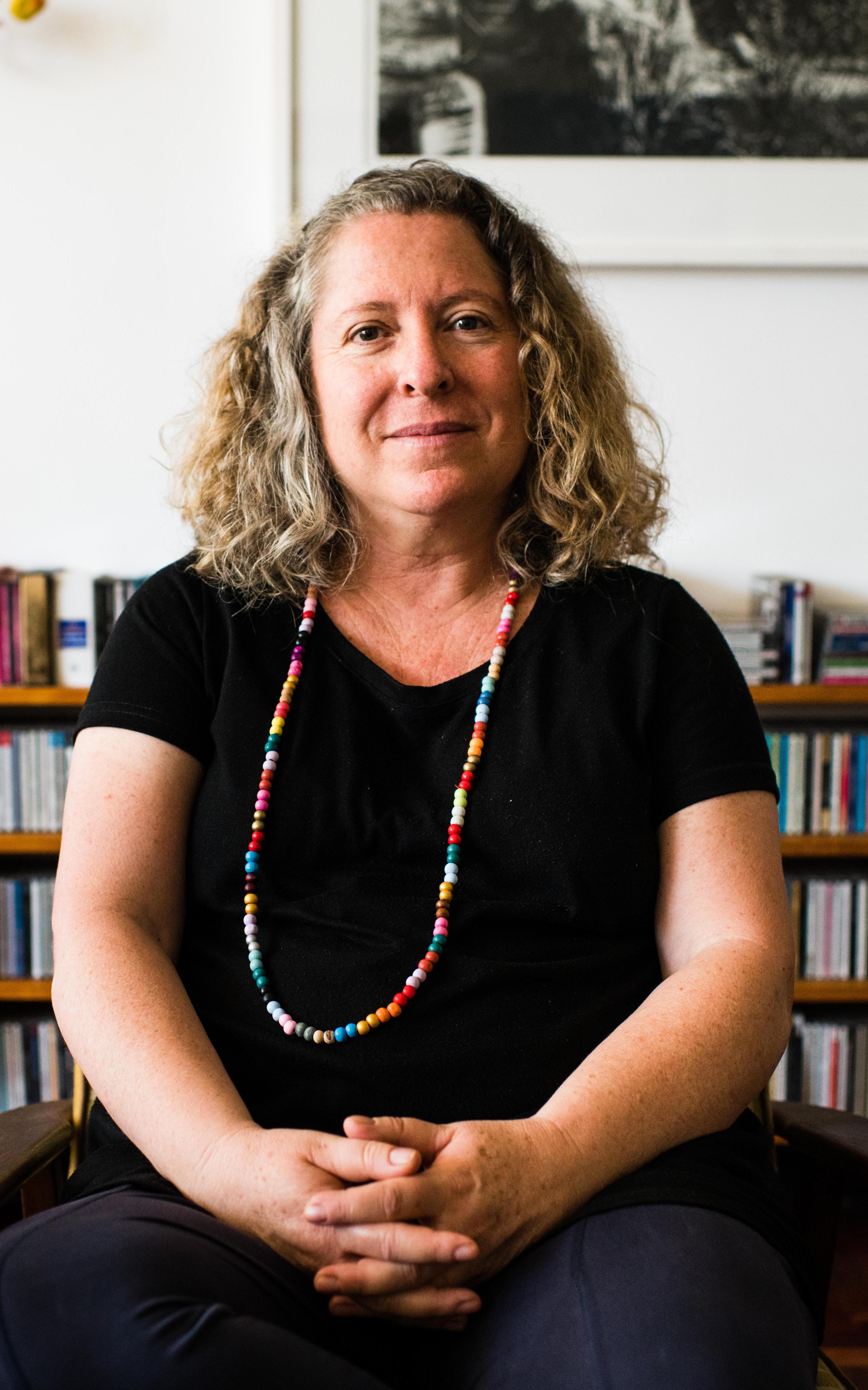 Woman sits in front of a bookshelf