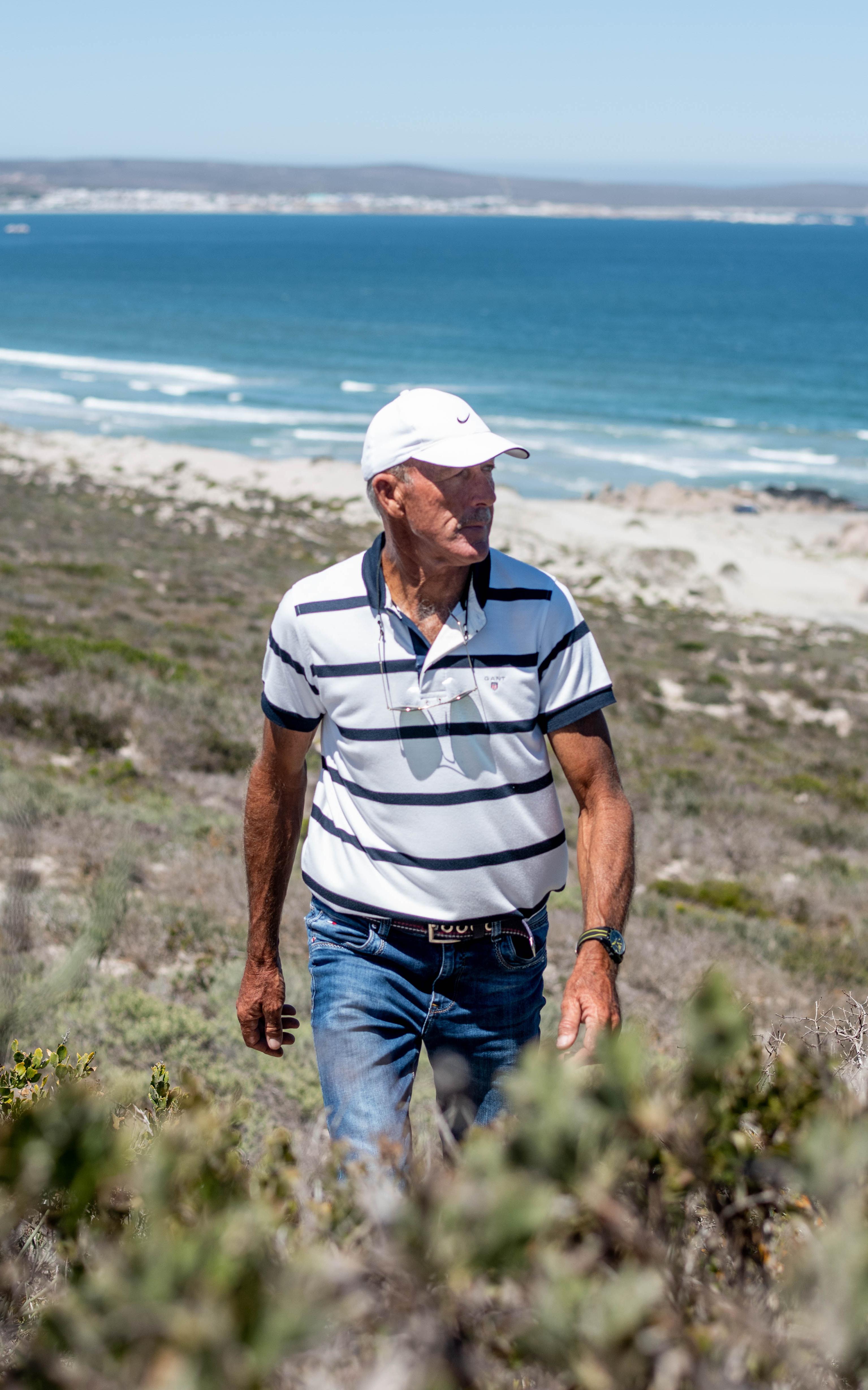 Man walking with ocean behind him
