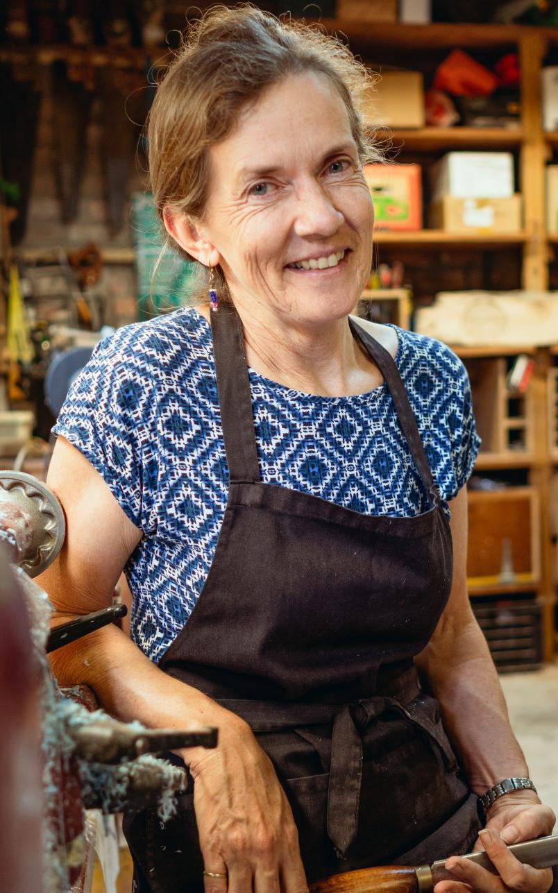 White woman sitting at table in studio.