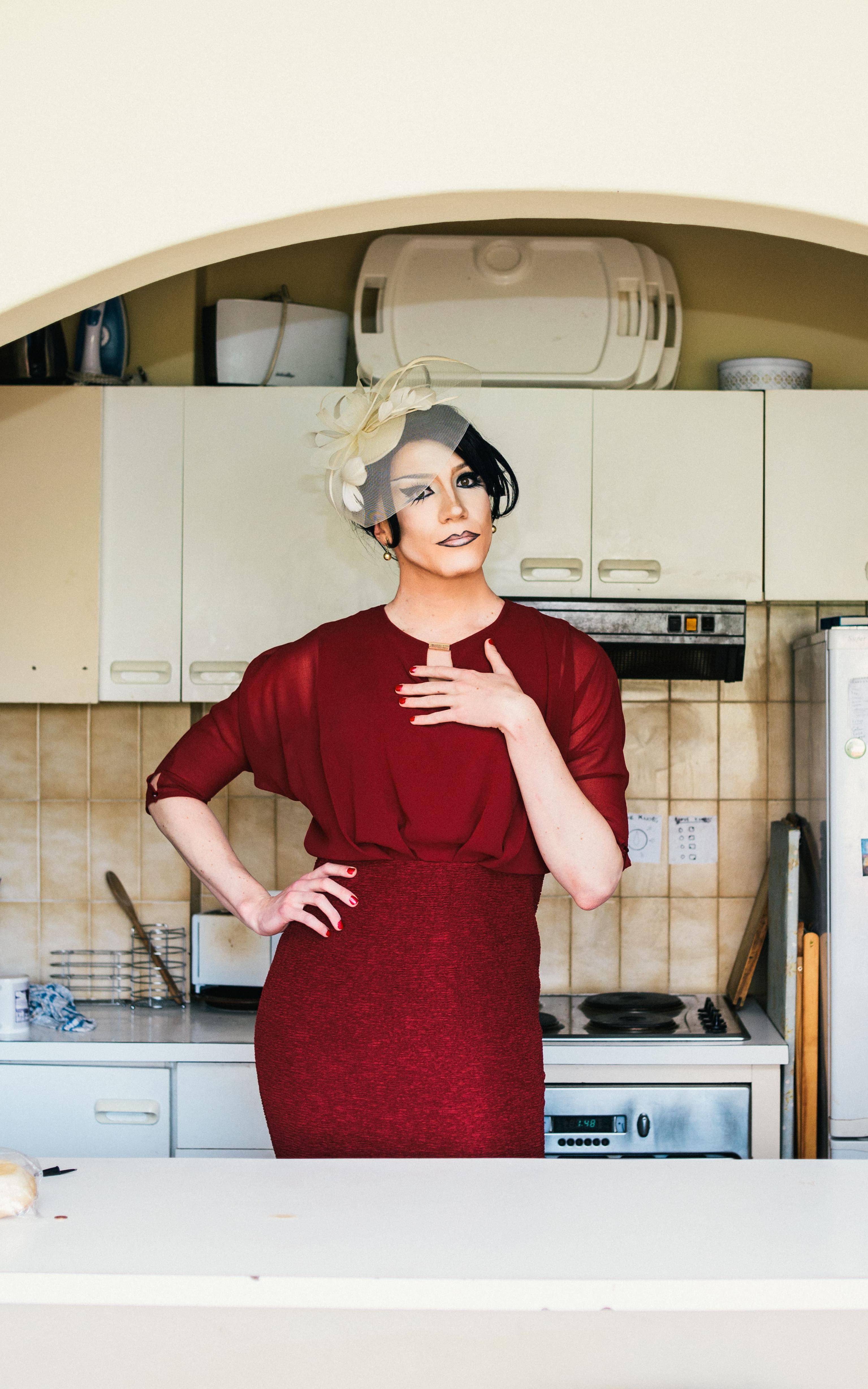 Man in drag standing in a kitchen