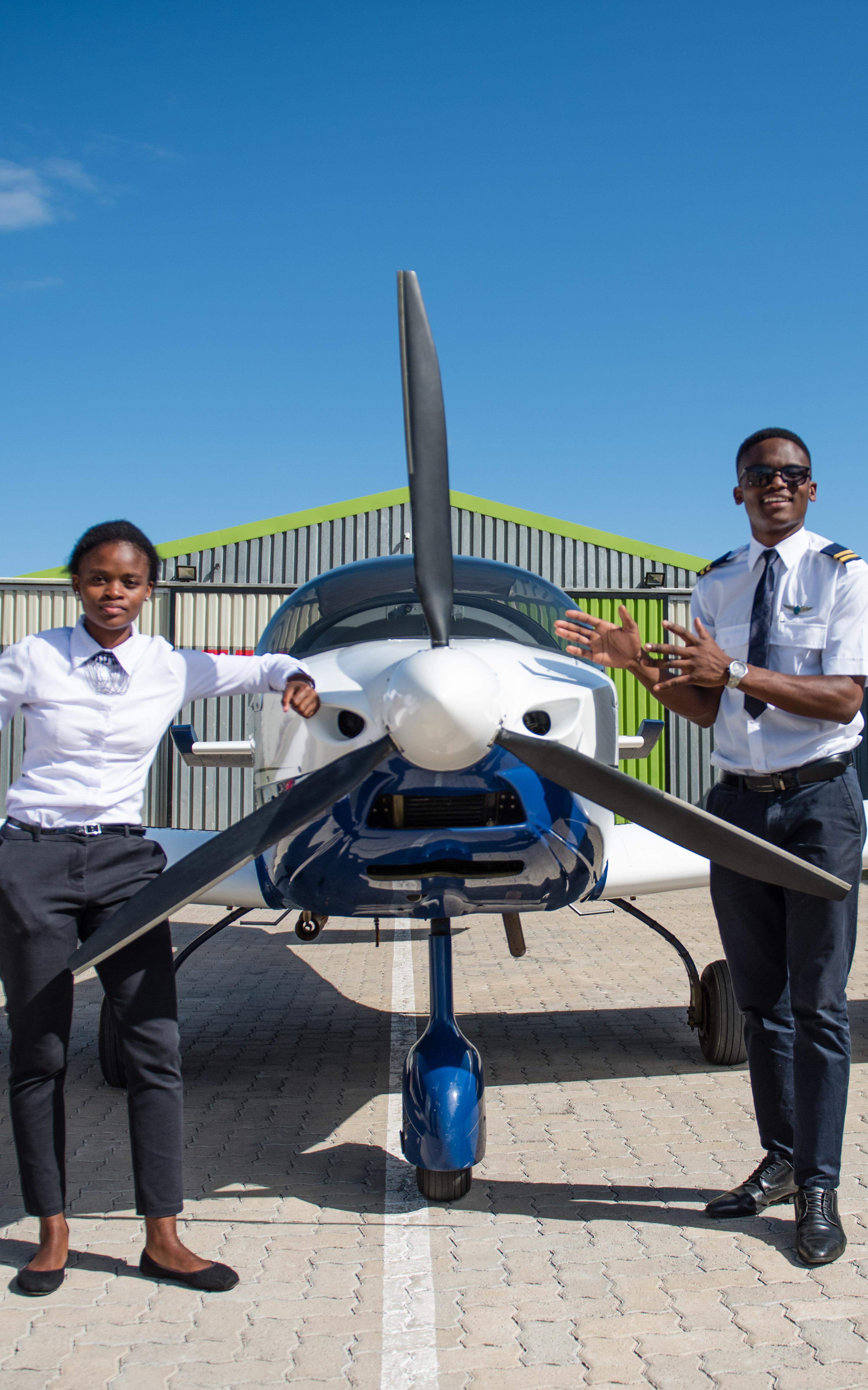 Two pilots standing in front of plane