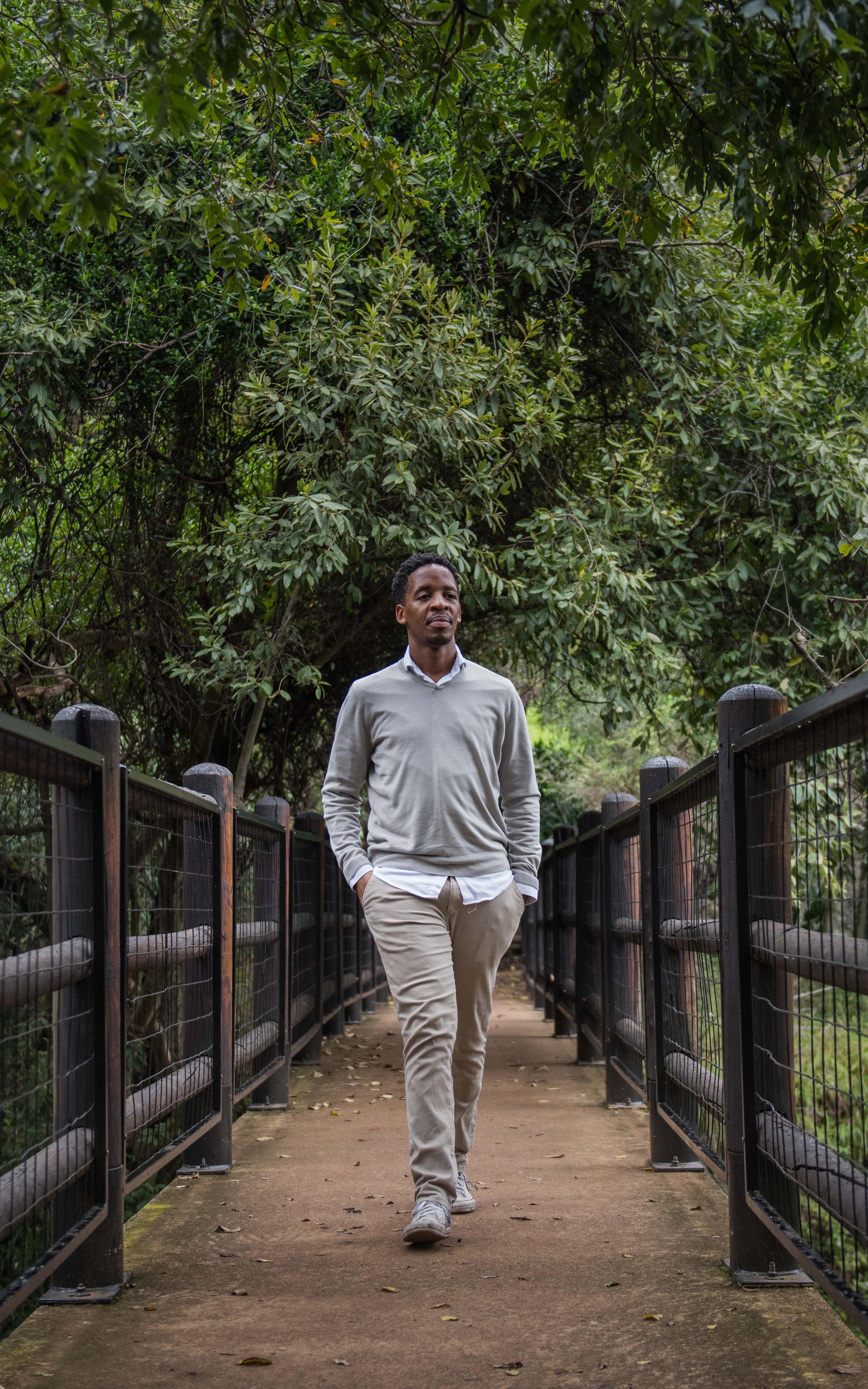 Man walks on a bridge through a forest