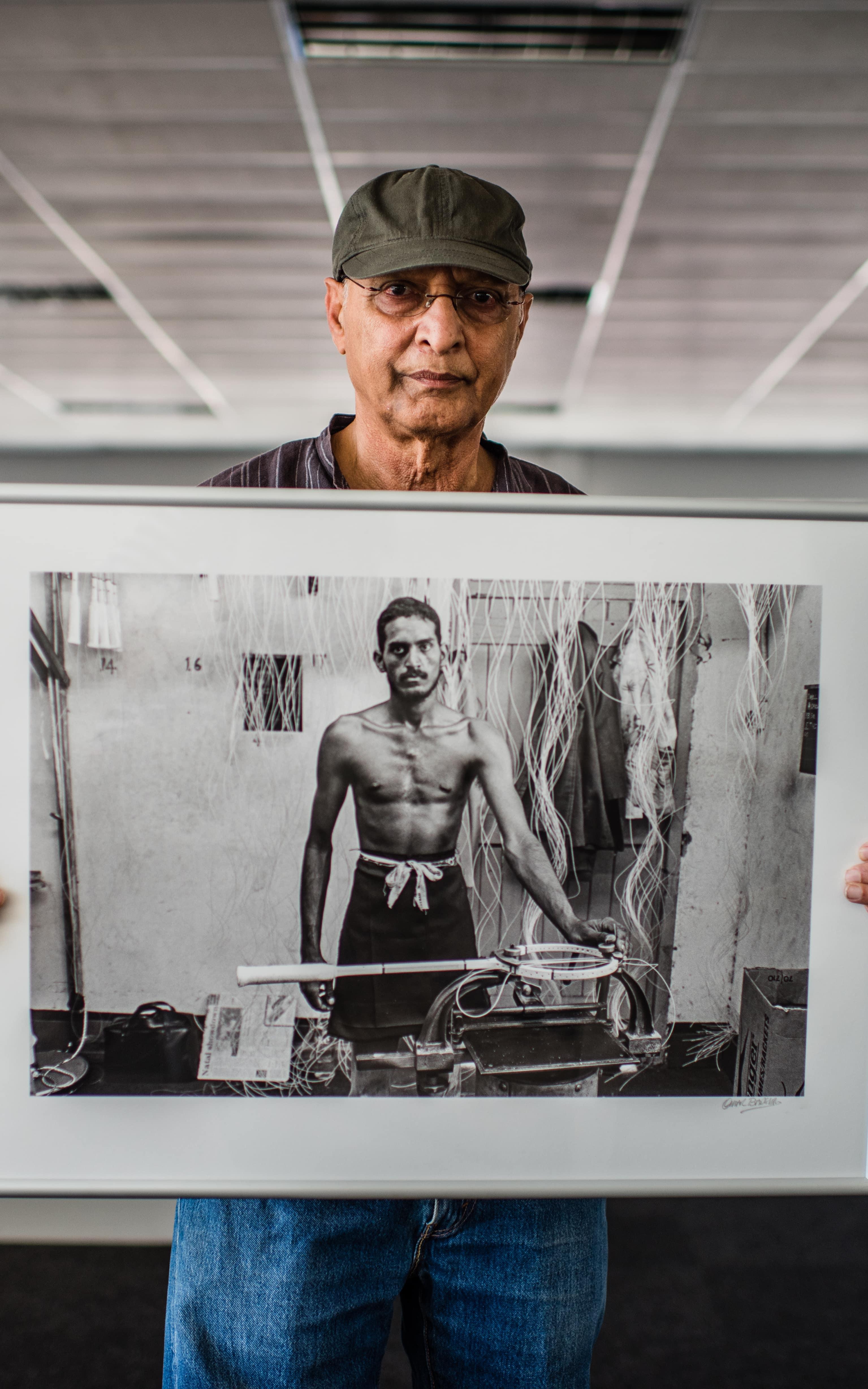 Photographer holding a framed photo he took.