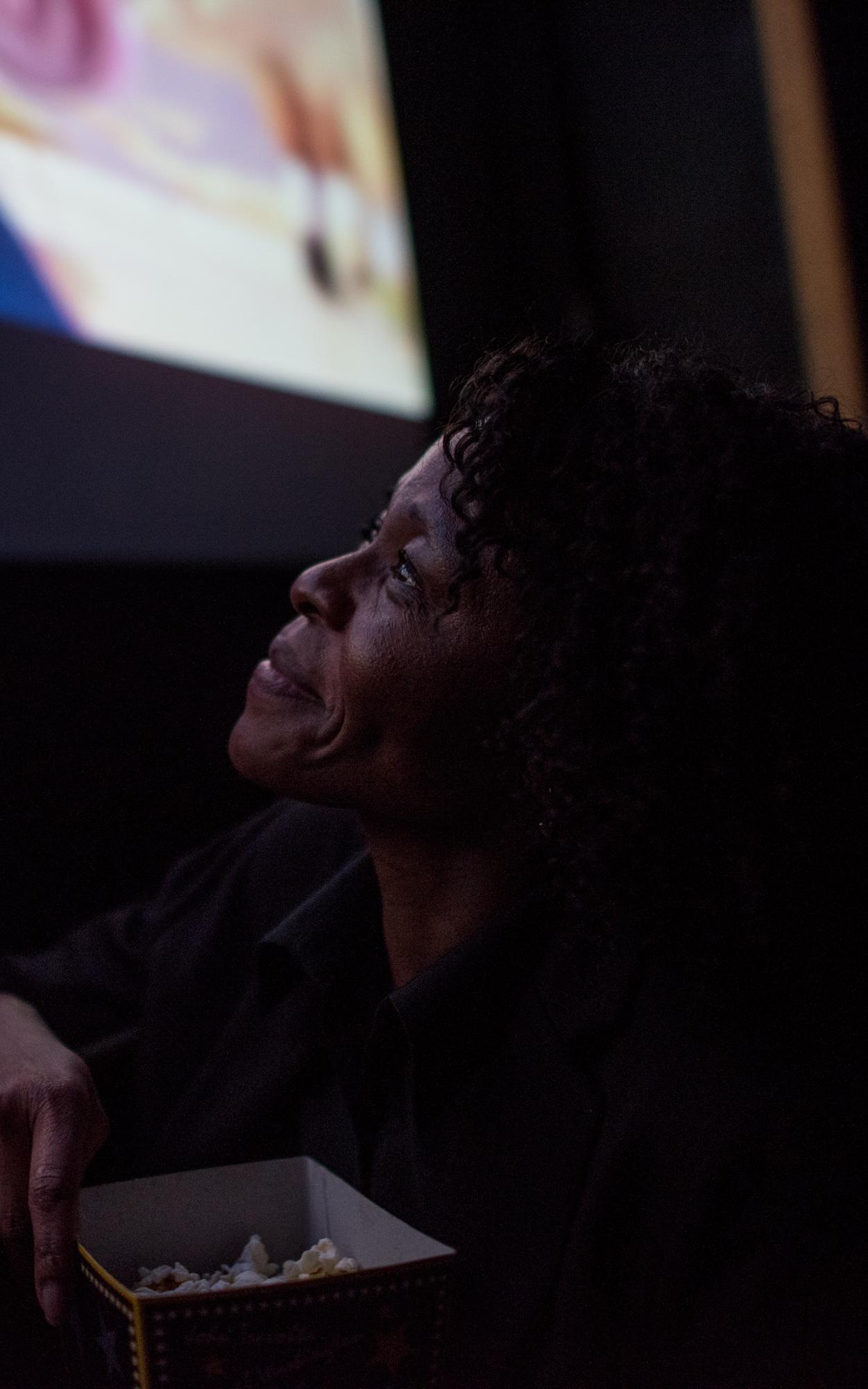 Woman smiling while looking up at a cinema screen