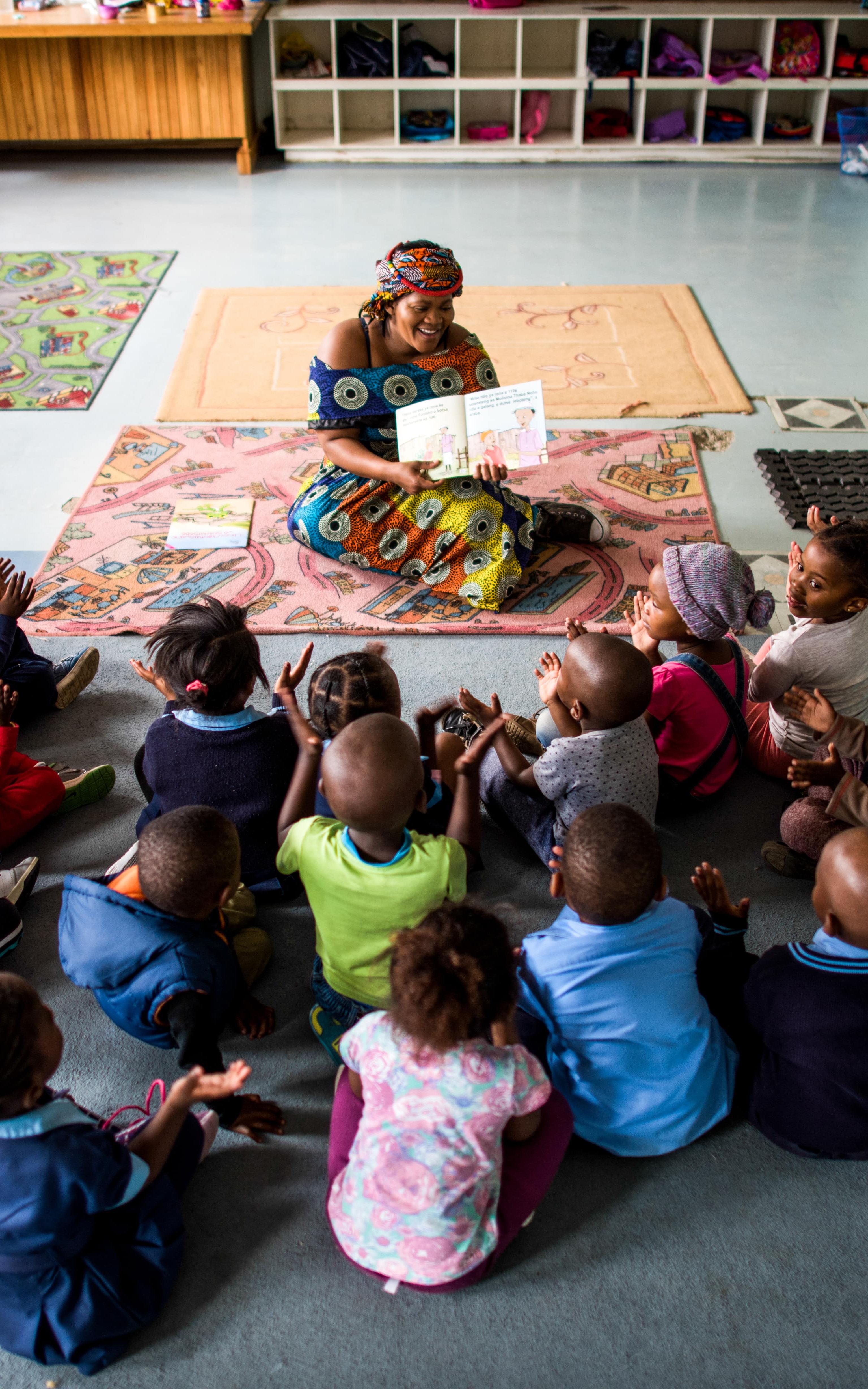 Woman reads to children. 