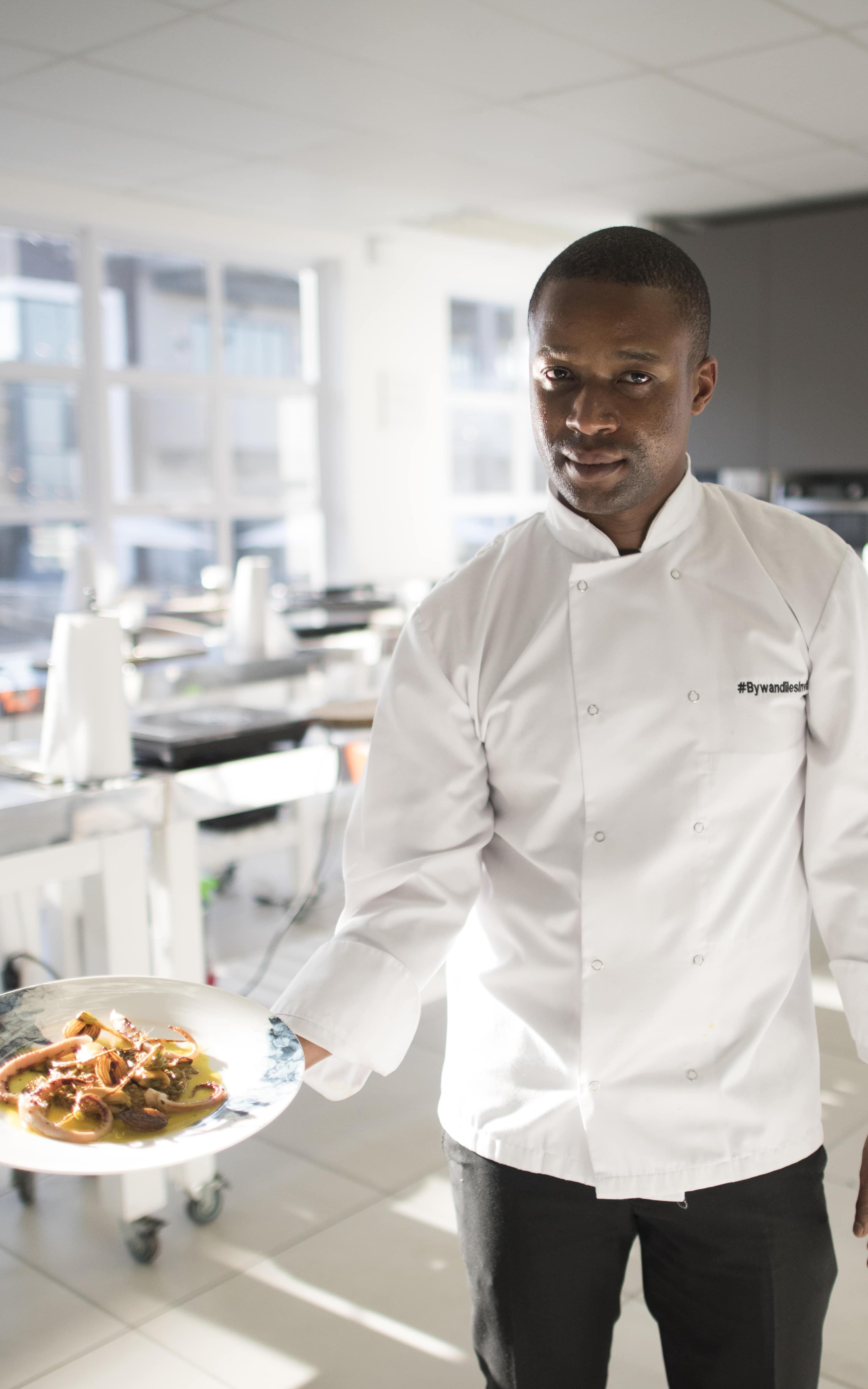 Black chef holding a plate