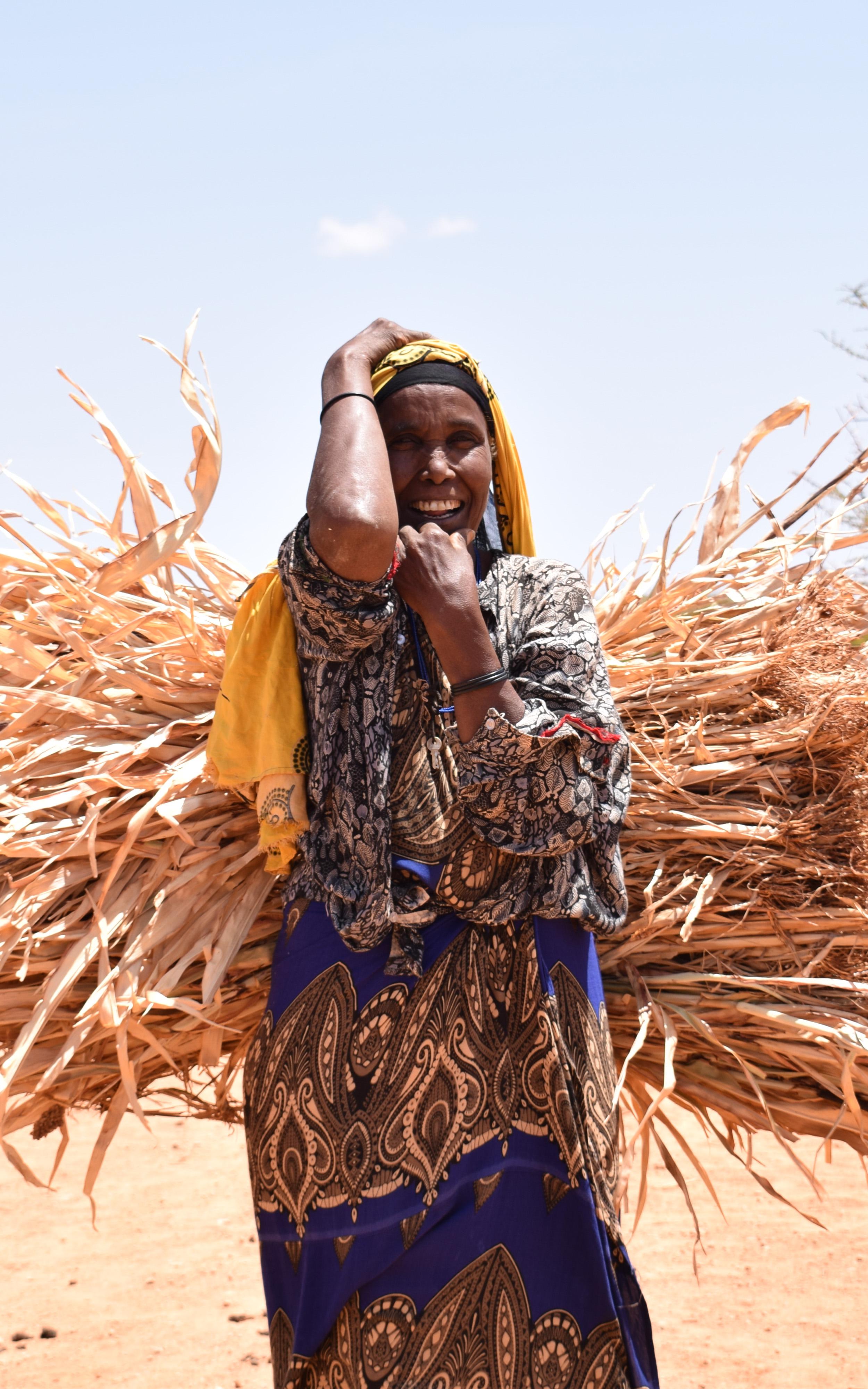 Beautiful News-Smiling woman carrying leaves in desert