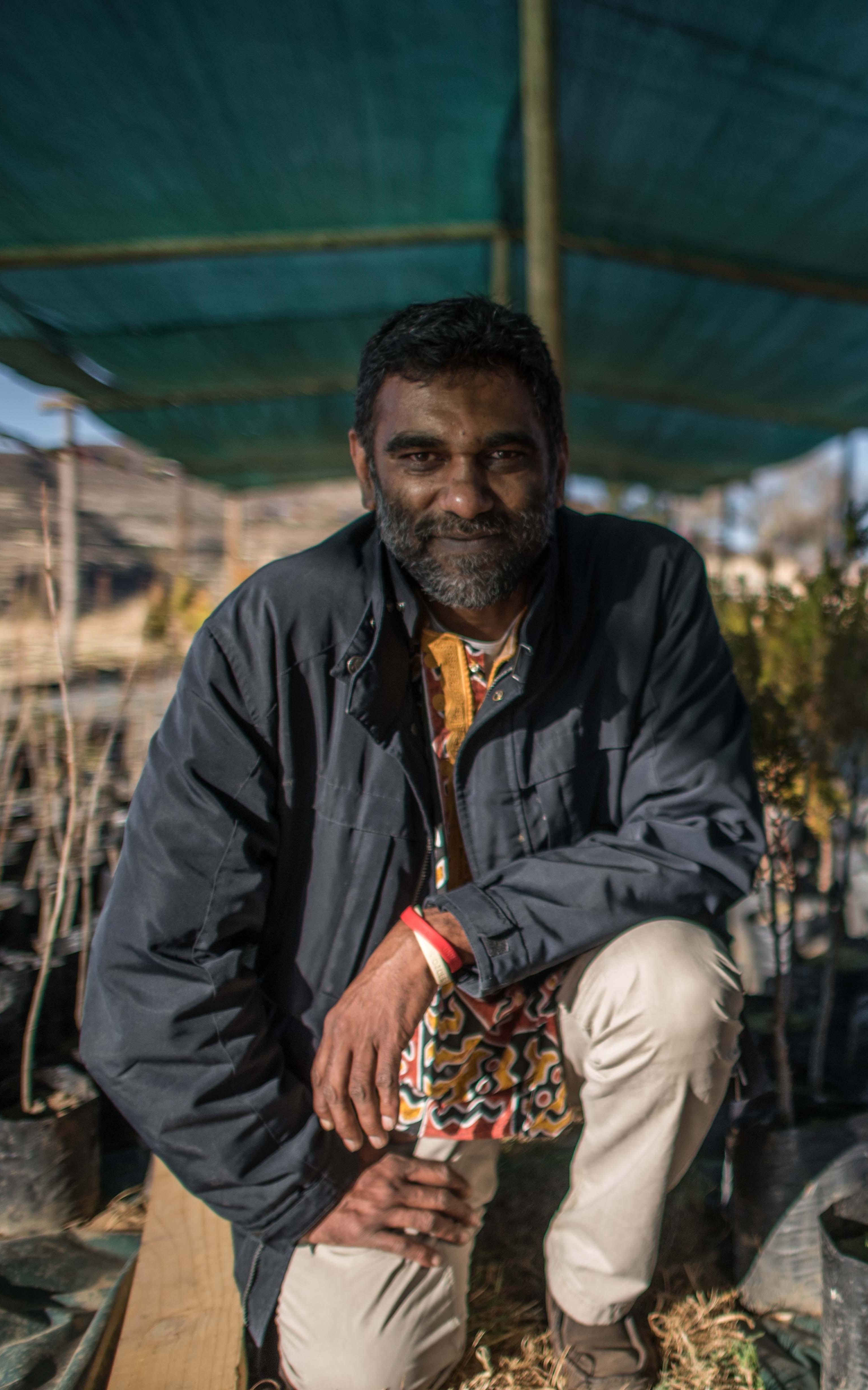 Indian man smiling between trees