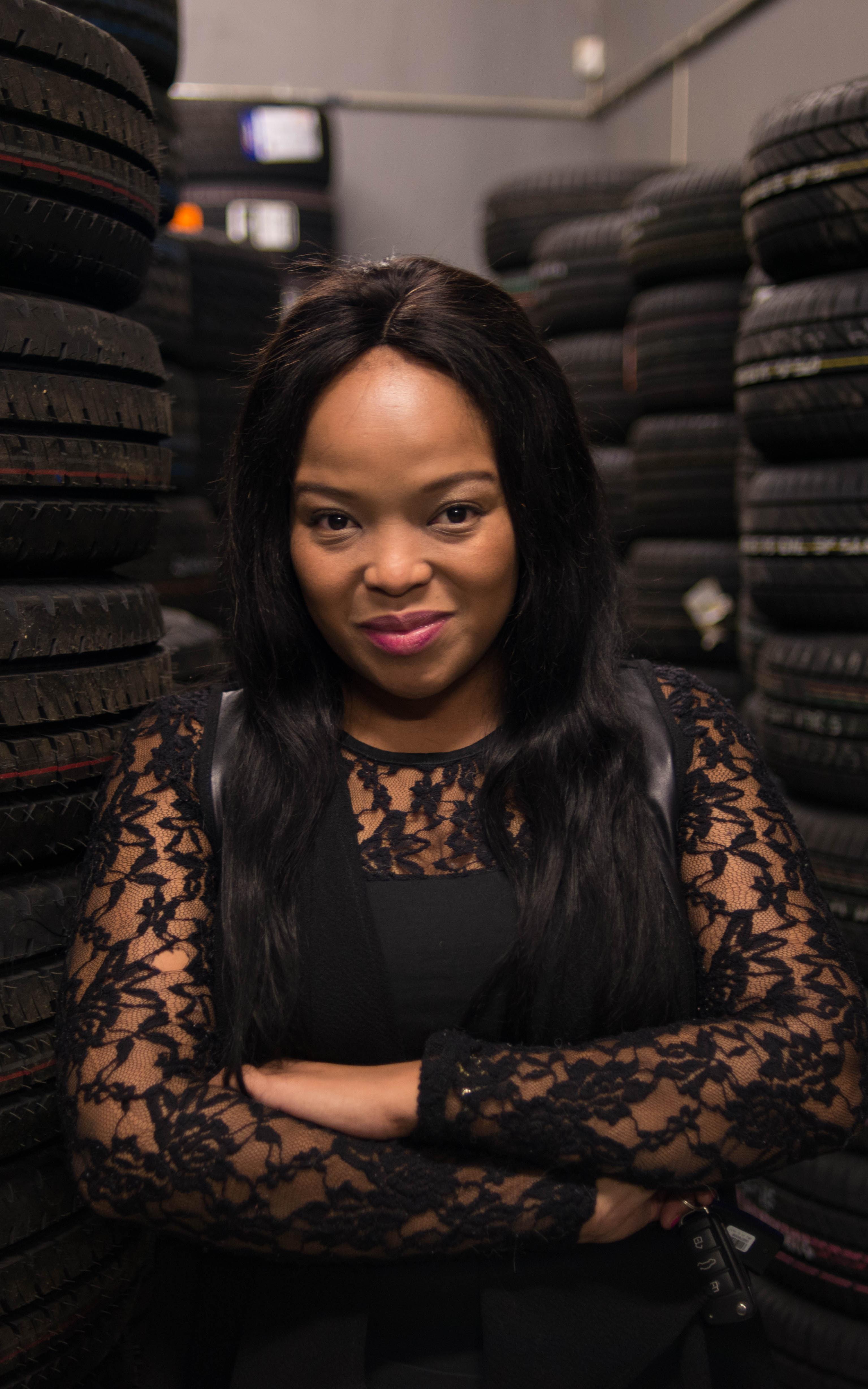 Woman standing between car tyres 