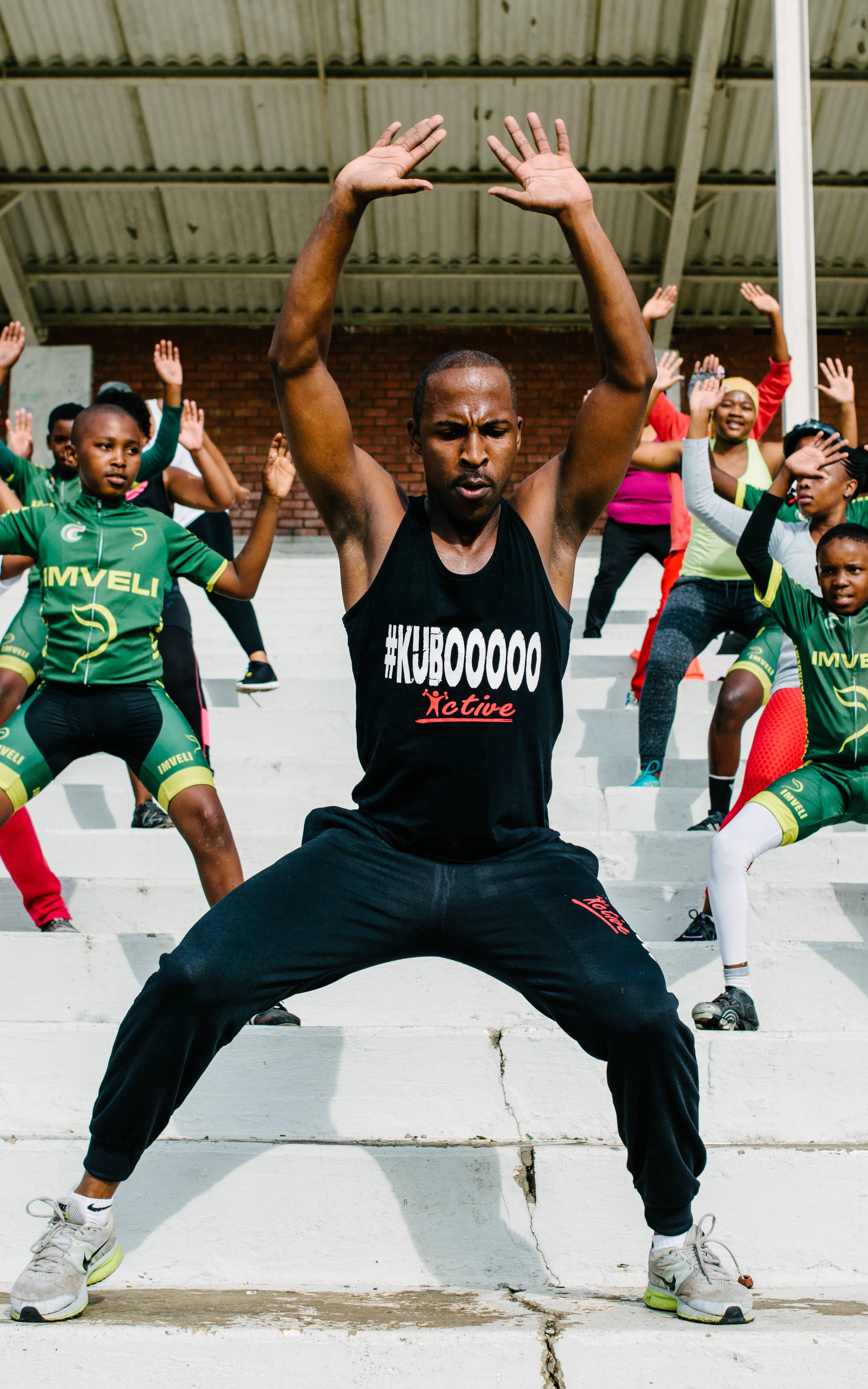 Man instructing children on how to do exercise