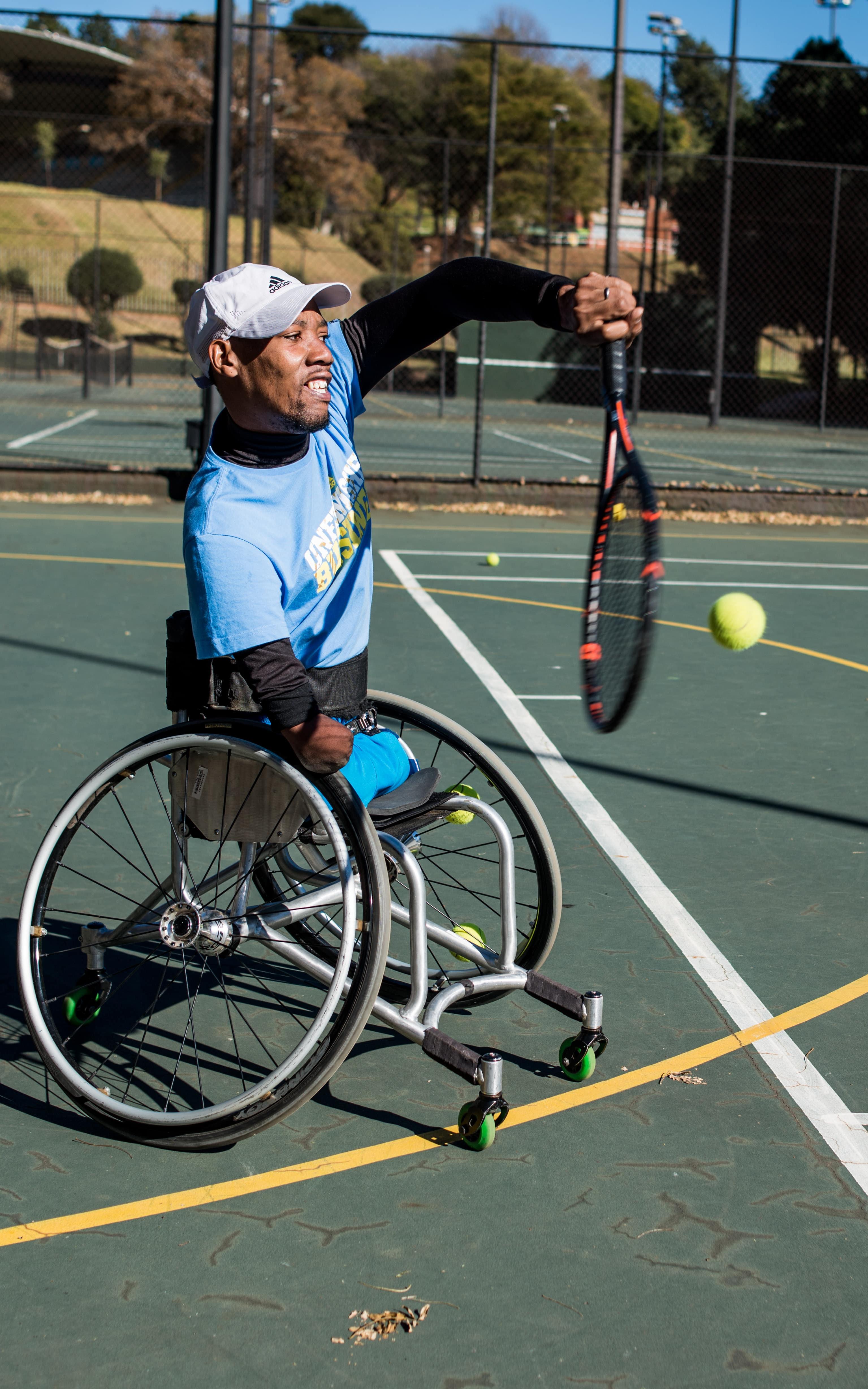 Man in a wheelchair plays tennis