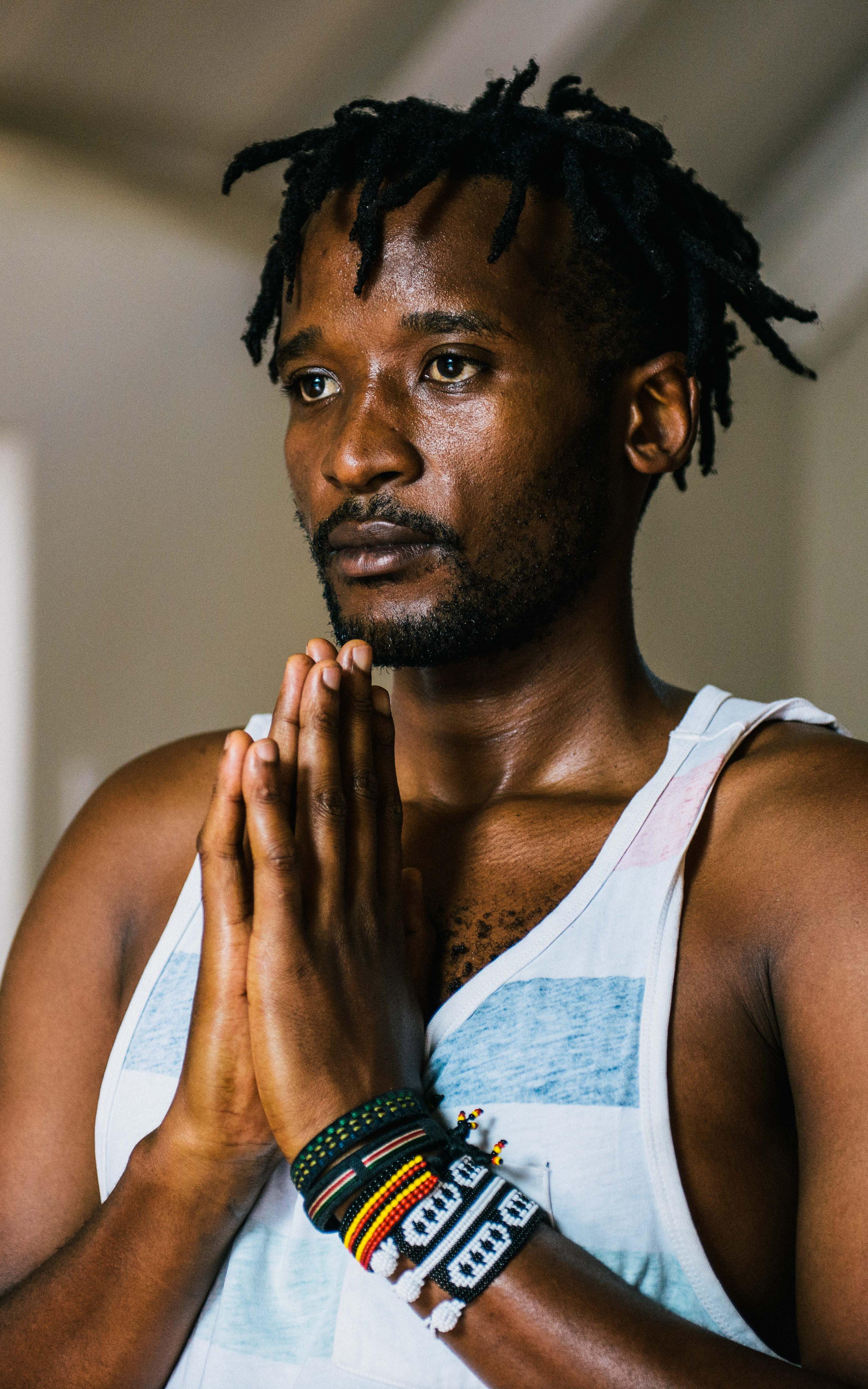 Man stands in a yoga position with his palms pressed together