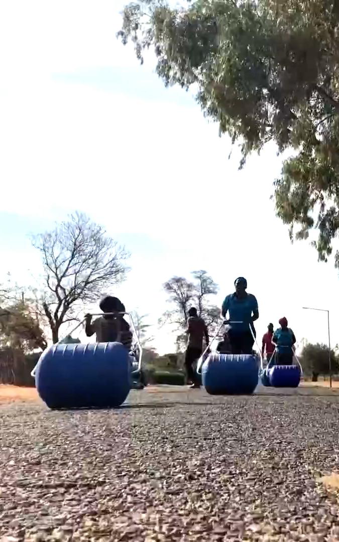 Beautiful News- People rolling water buckets