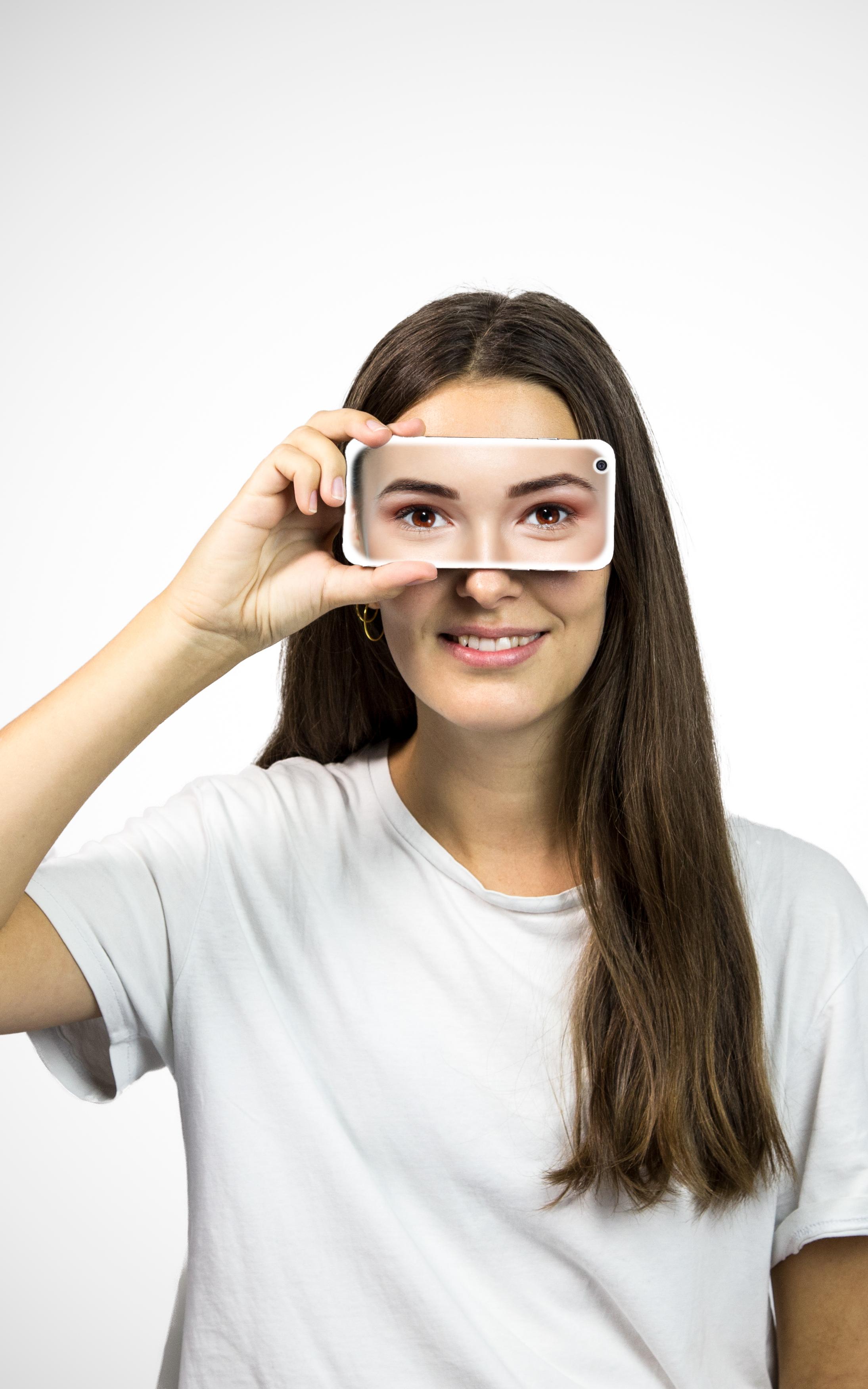 Women holding phone to her eyes. 