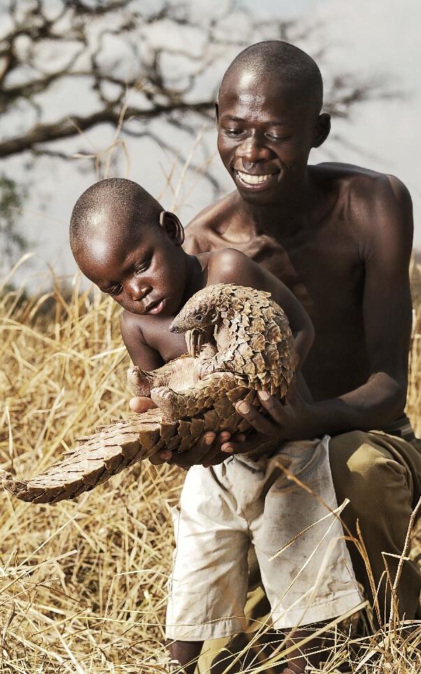 Father and son holding pangolin
