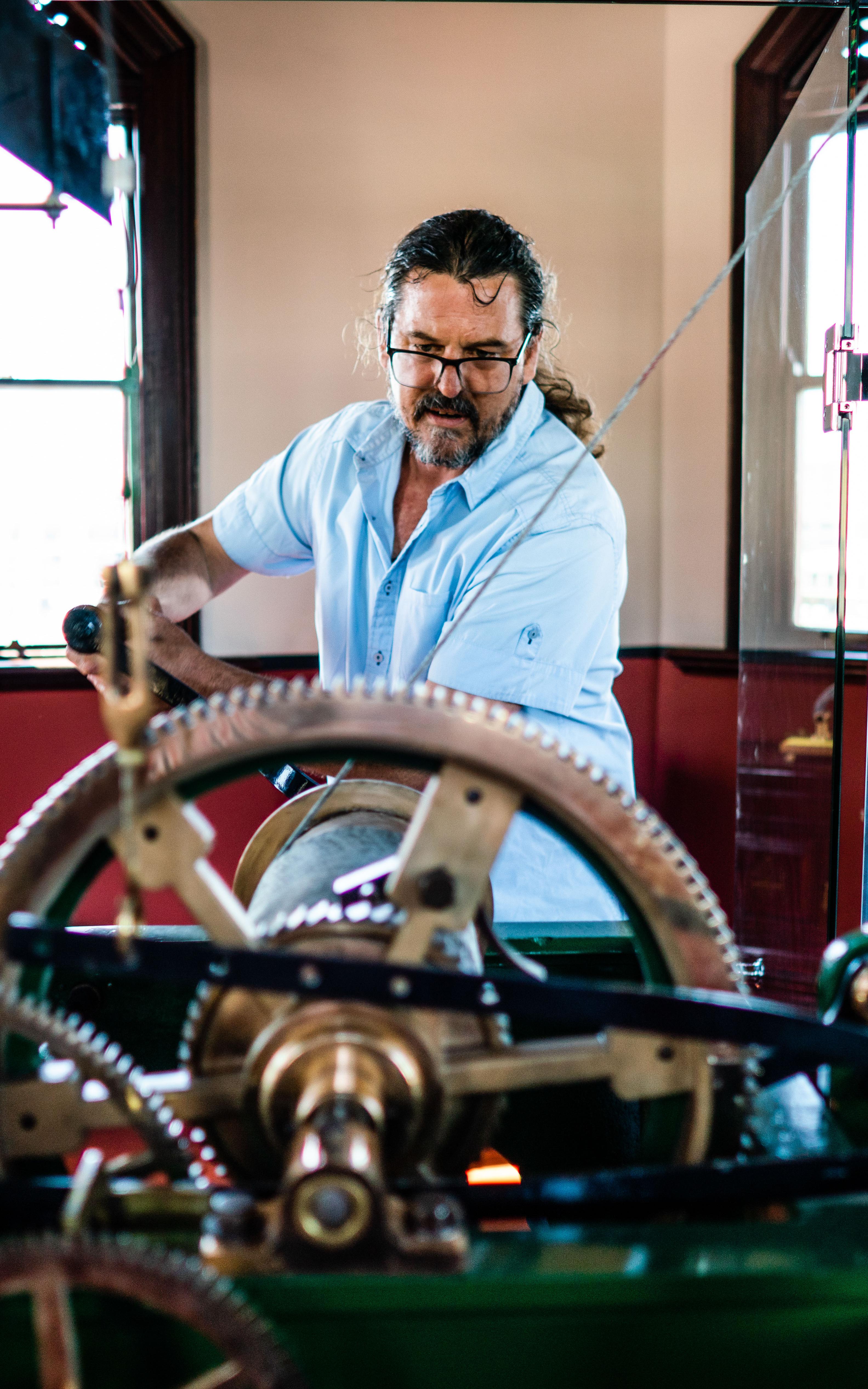 Man working on clock tower gears.