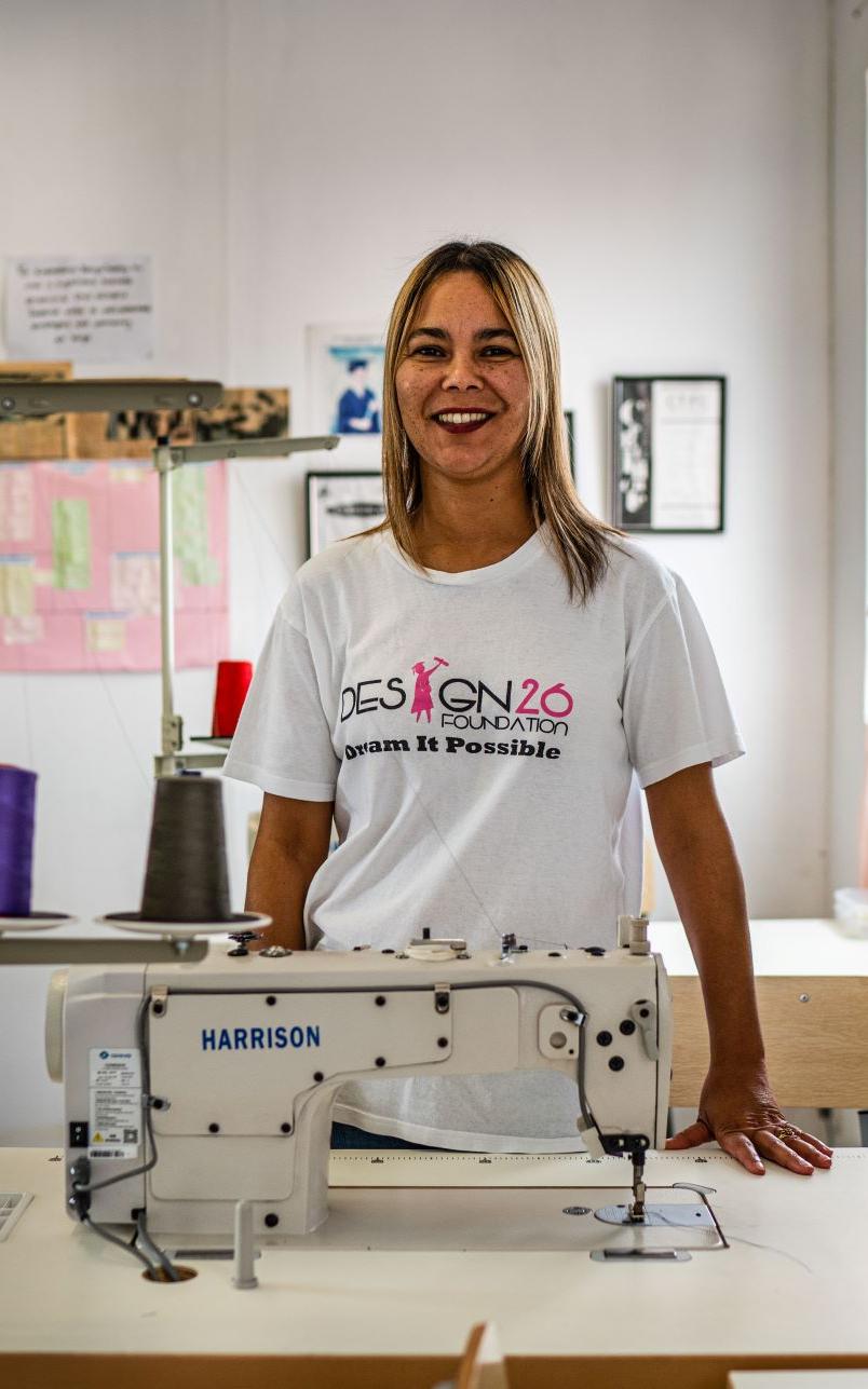 Coloured woman standing behind sewing machine