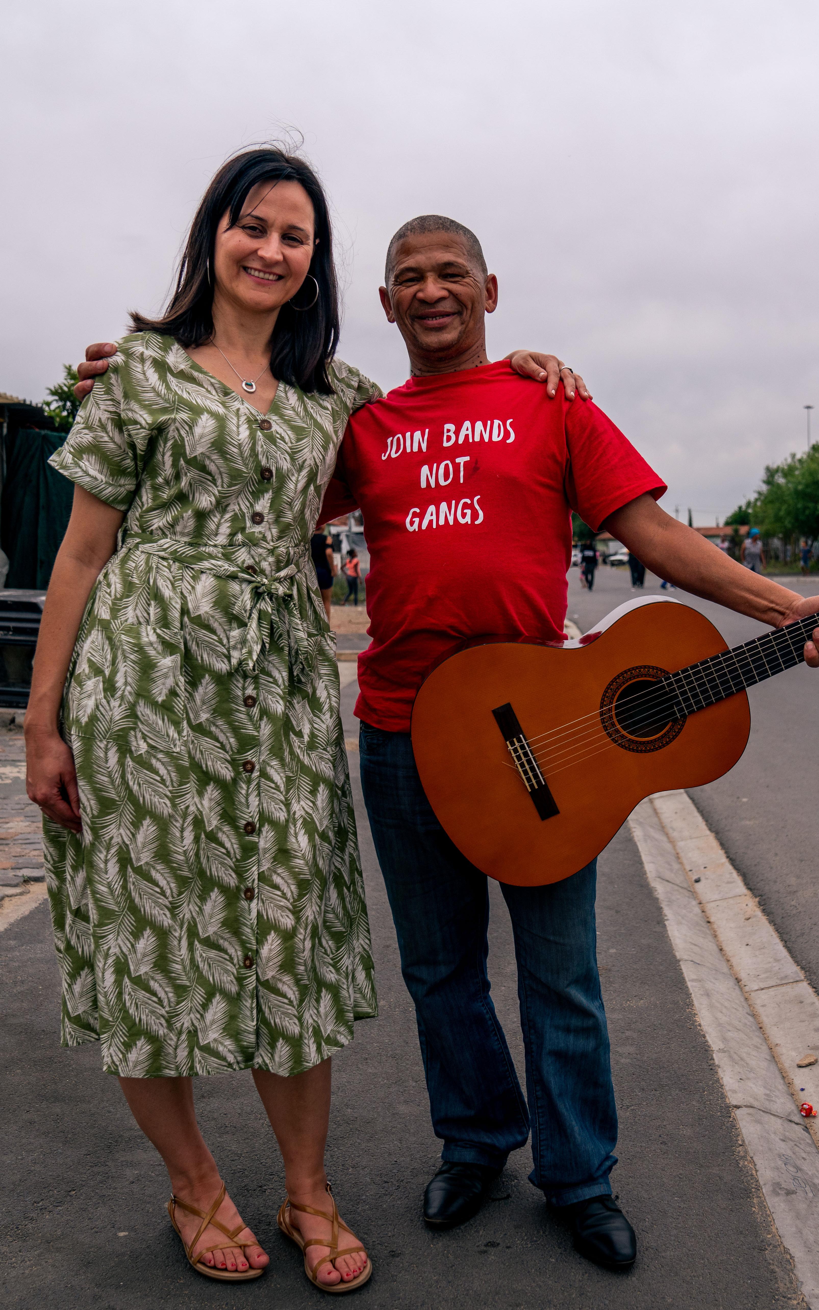 2 people. One holding a guitar