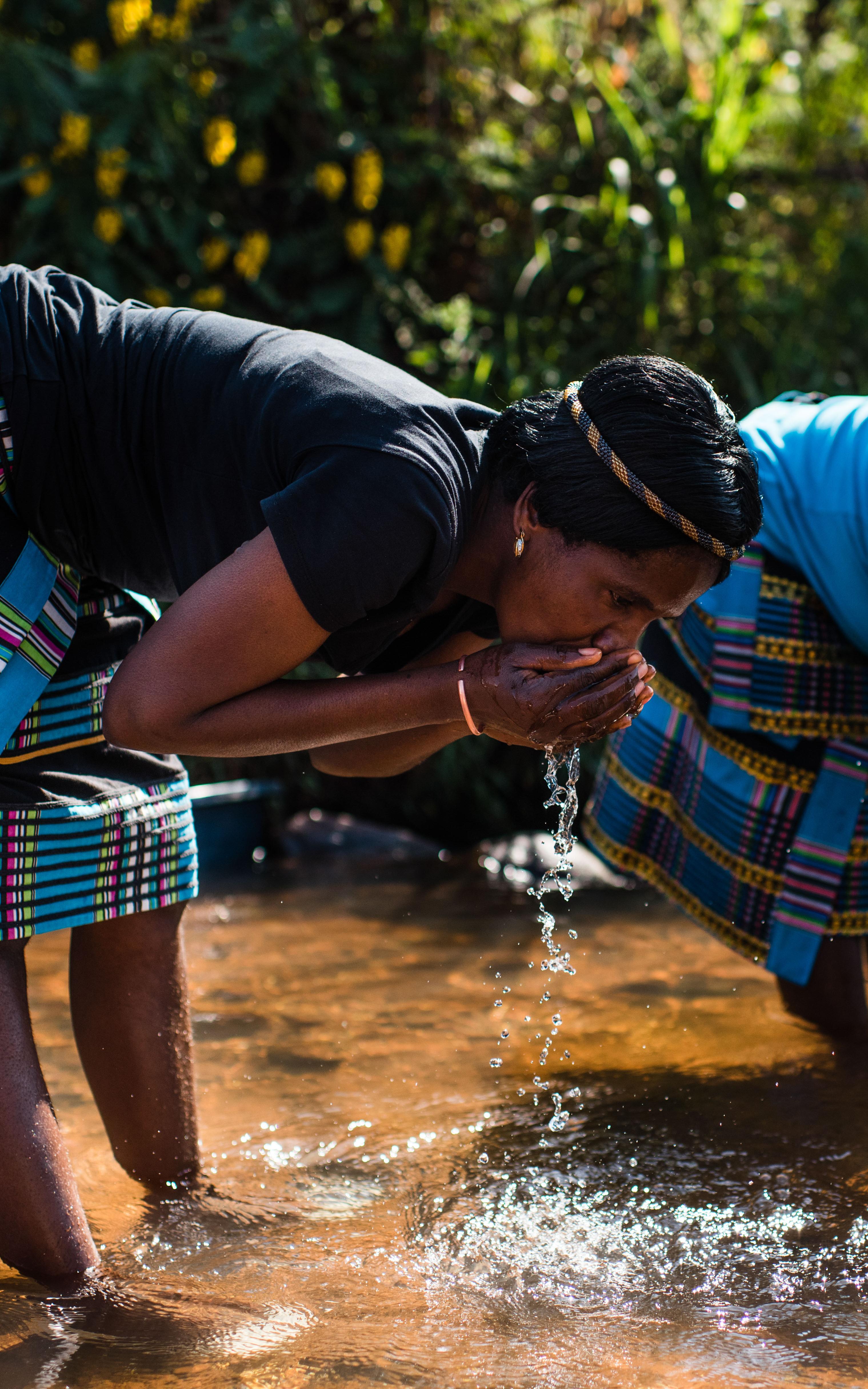 Women drinking out of a river. 