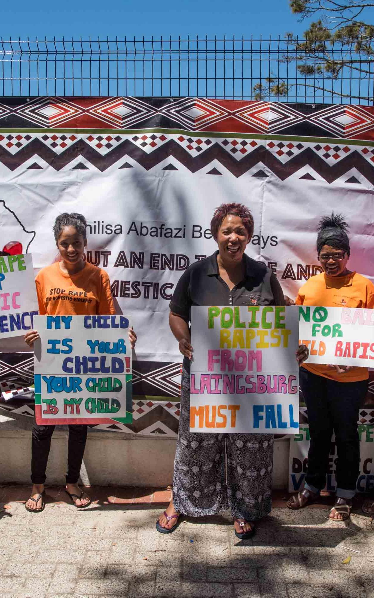 Group of woman standing with signs.