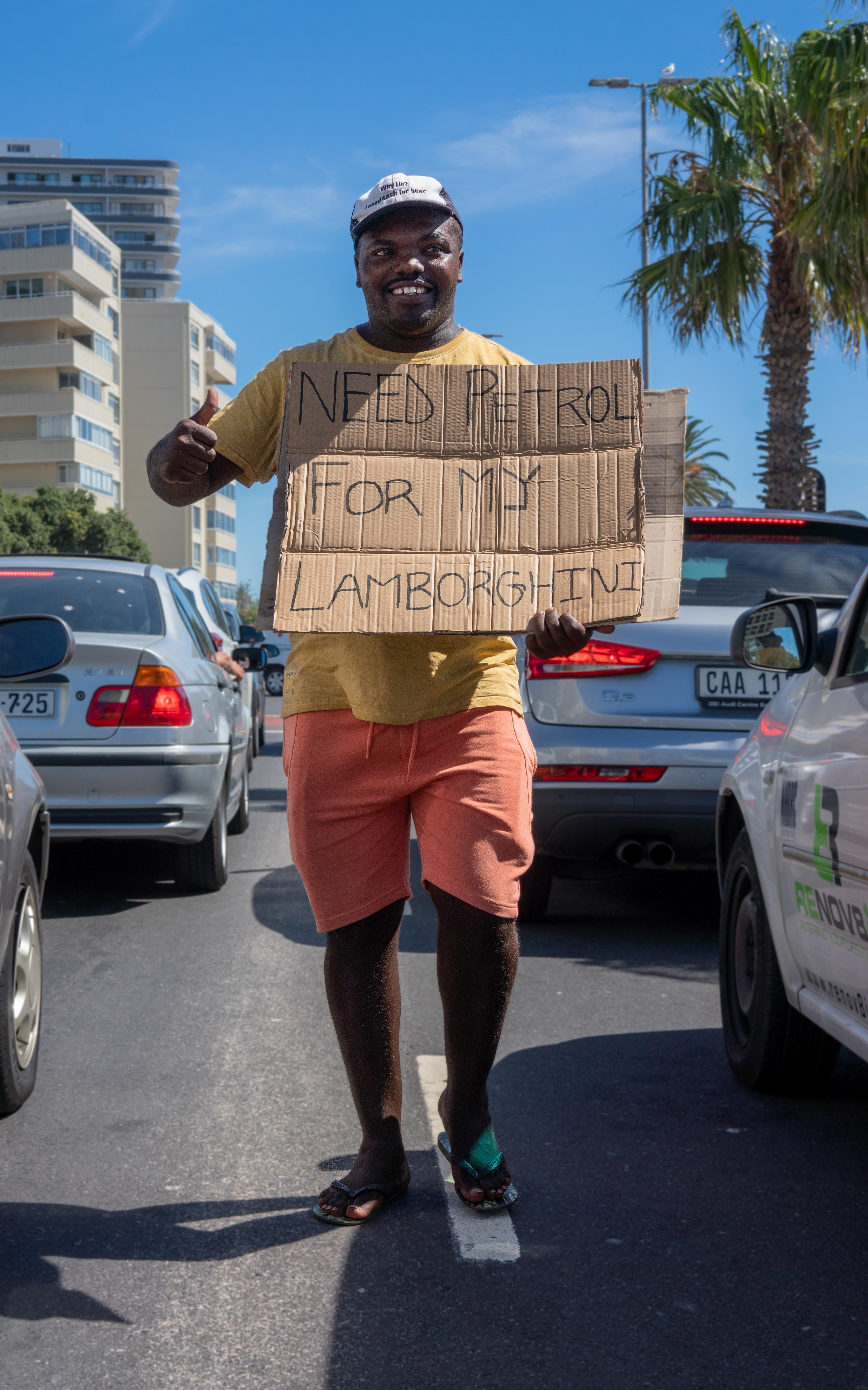 Beautiful News-Man holding humorous sign in traffic. 