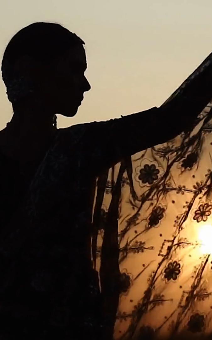 Beautiful News - Lady standing as silhouette against backdrop of sun in Varanasi India