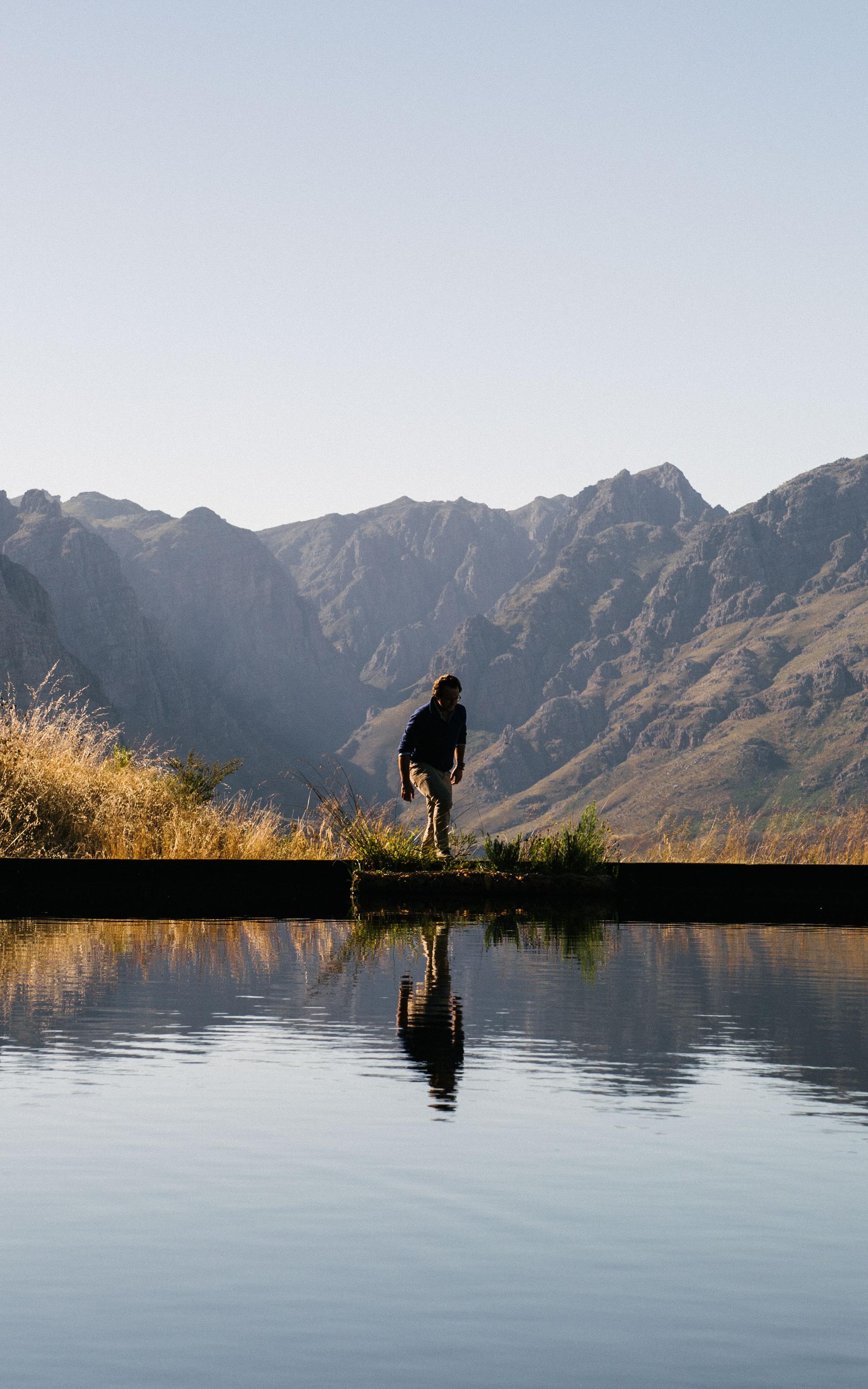 Man standing over a dam in the mountains
