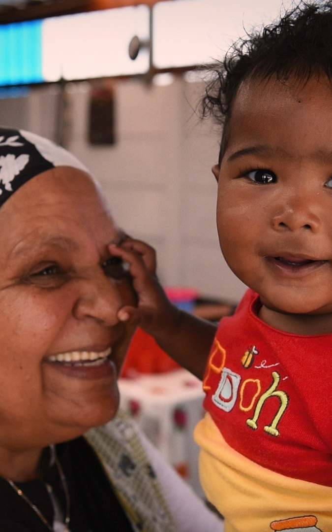 Coloured woman and child smiling into camera.