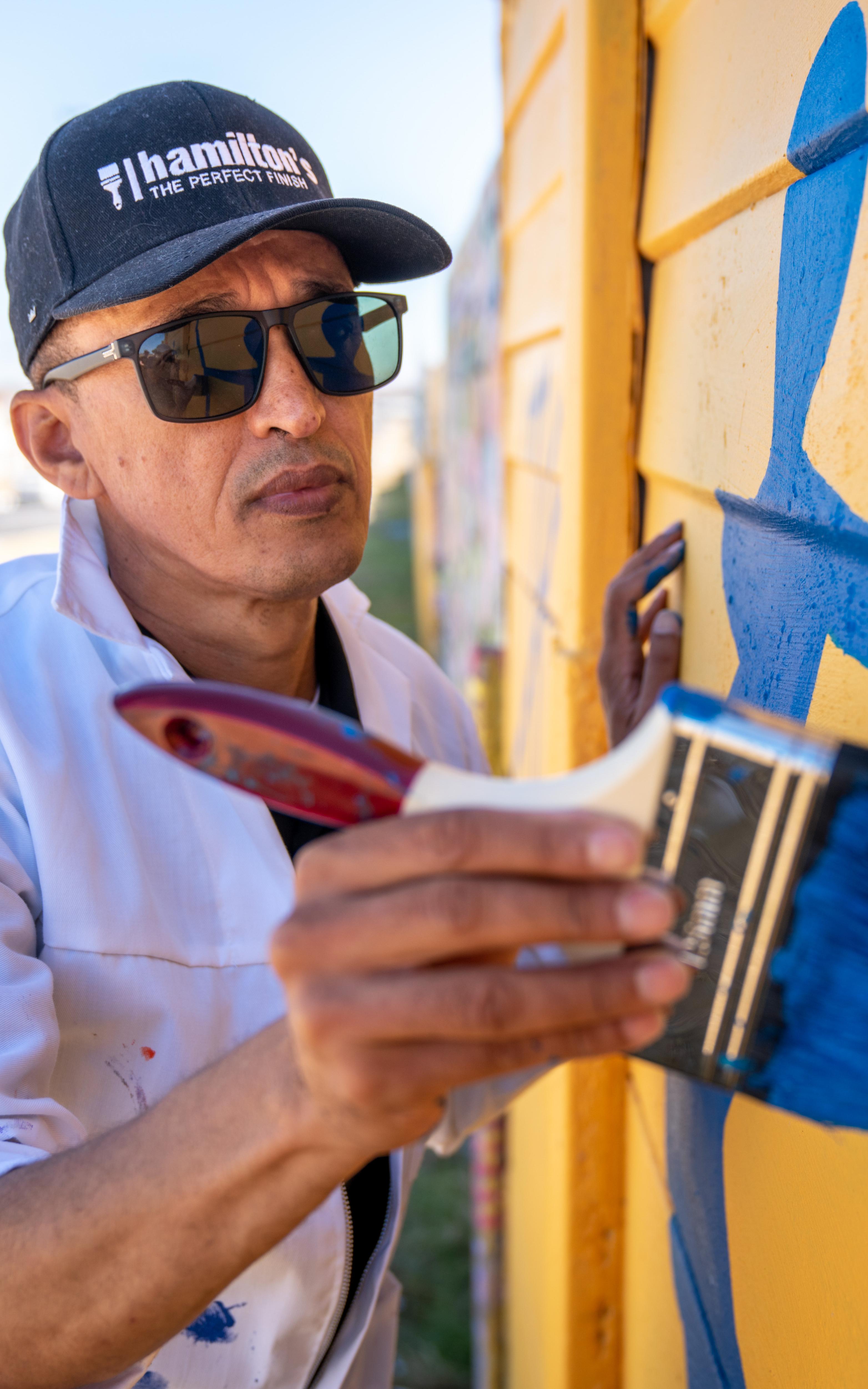 Michael Bell paints a Mitchells Plain wall