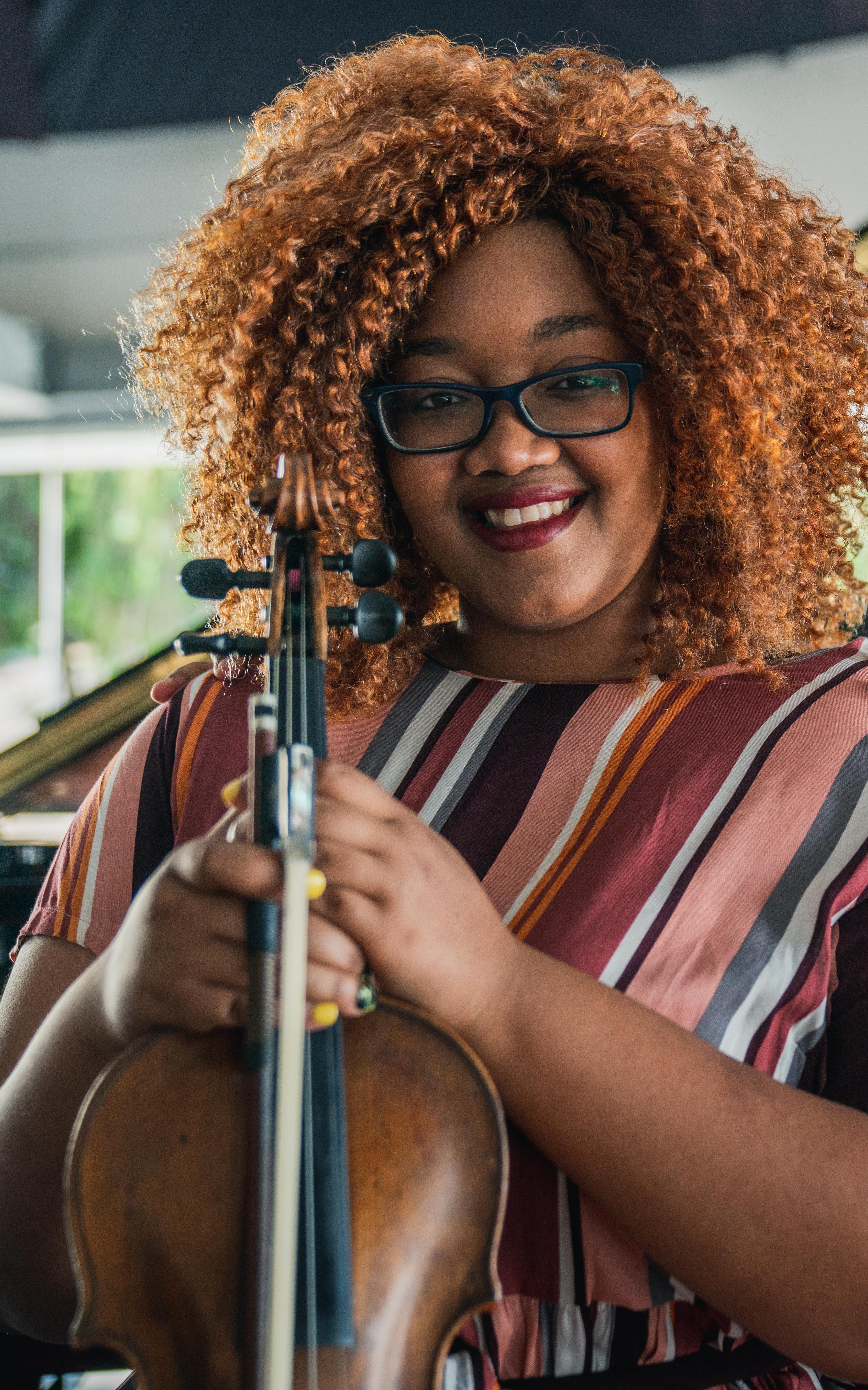 2 young women. One holding a violin