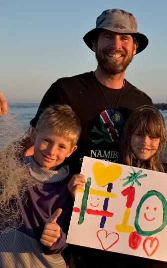 men and kids holding up a sign. 