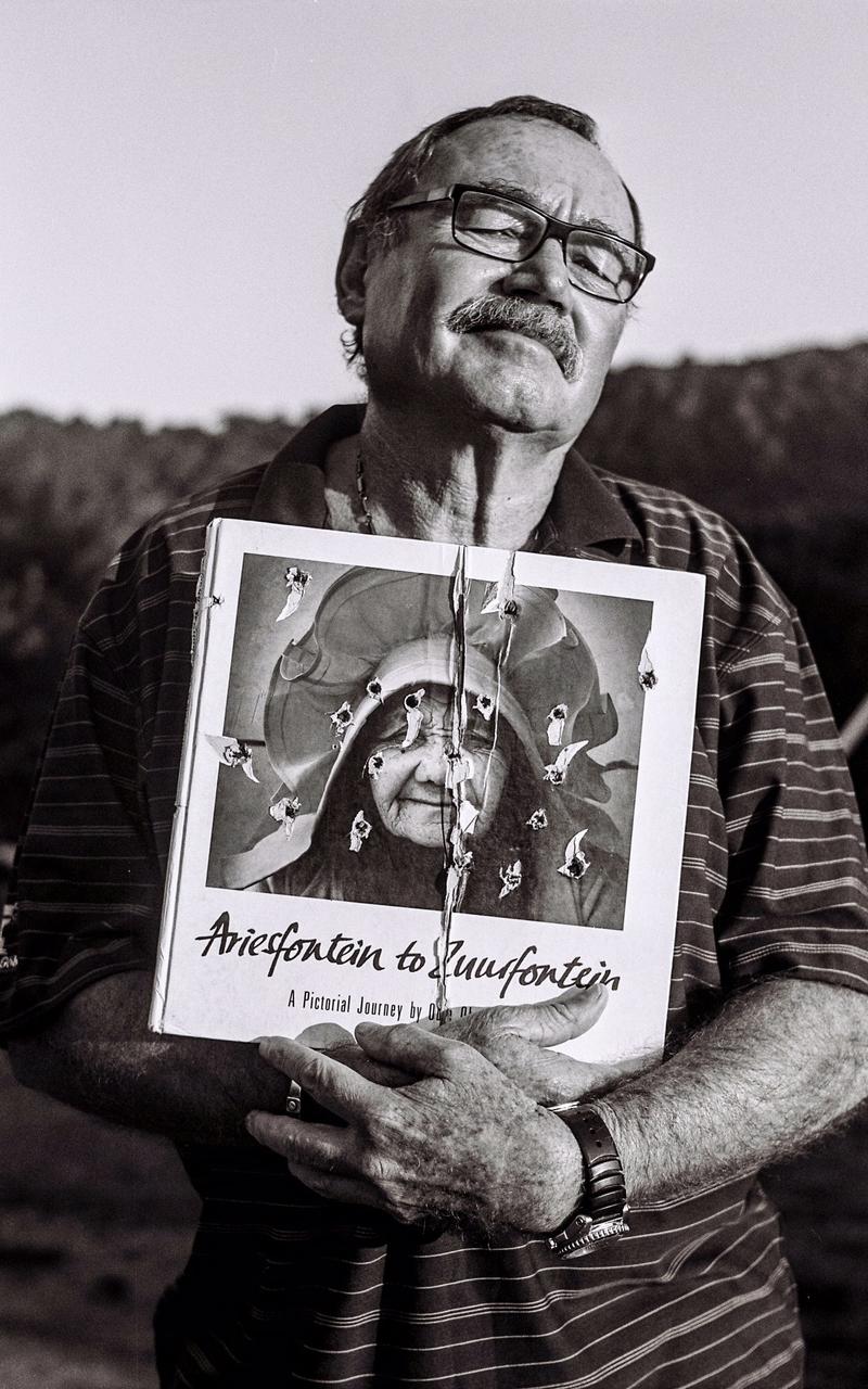 Photographer holding up photo album.