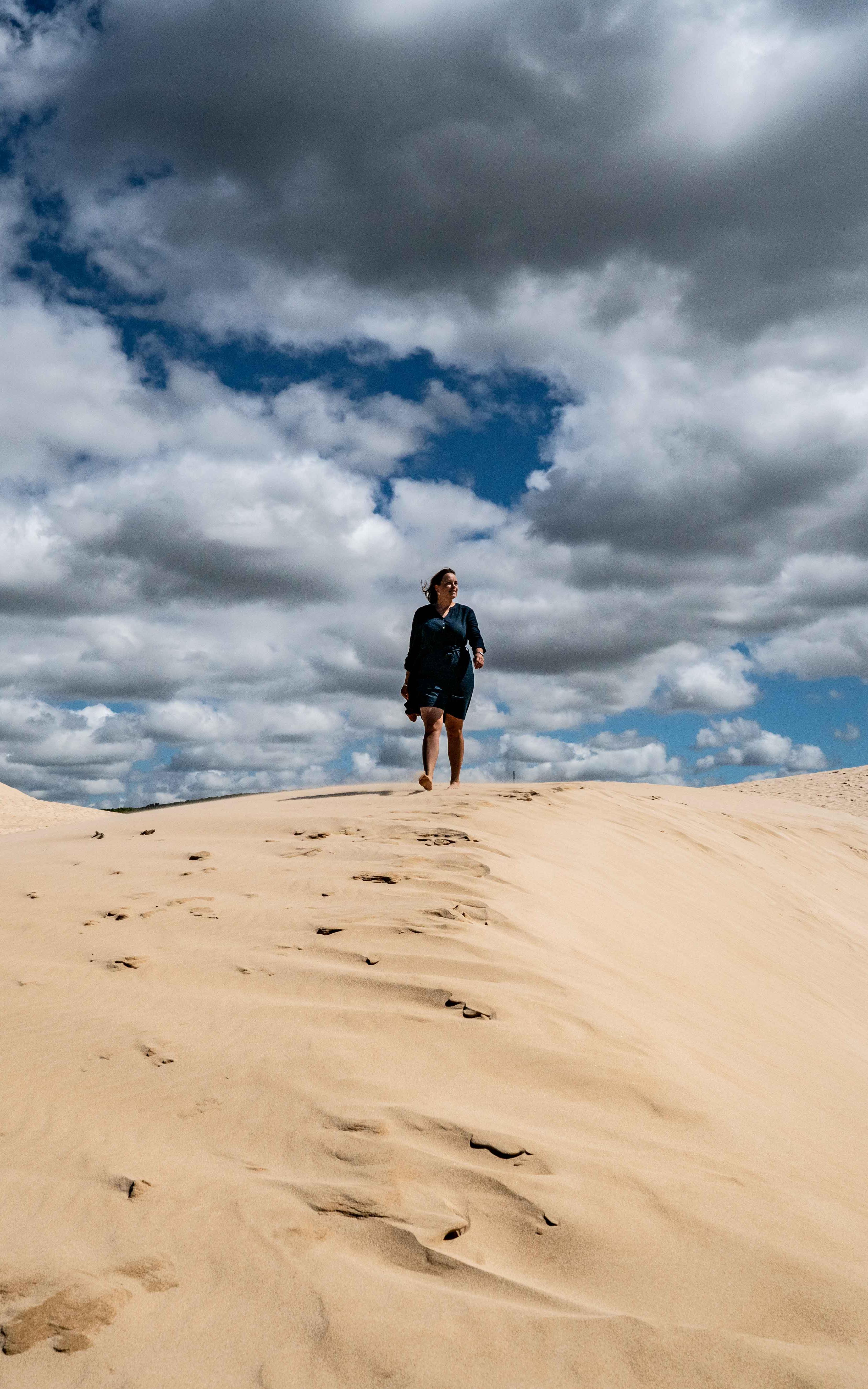 Woman walking on sand dune