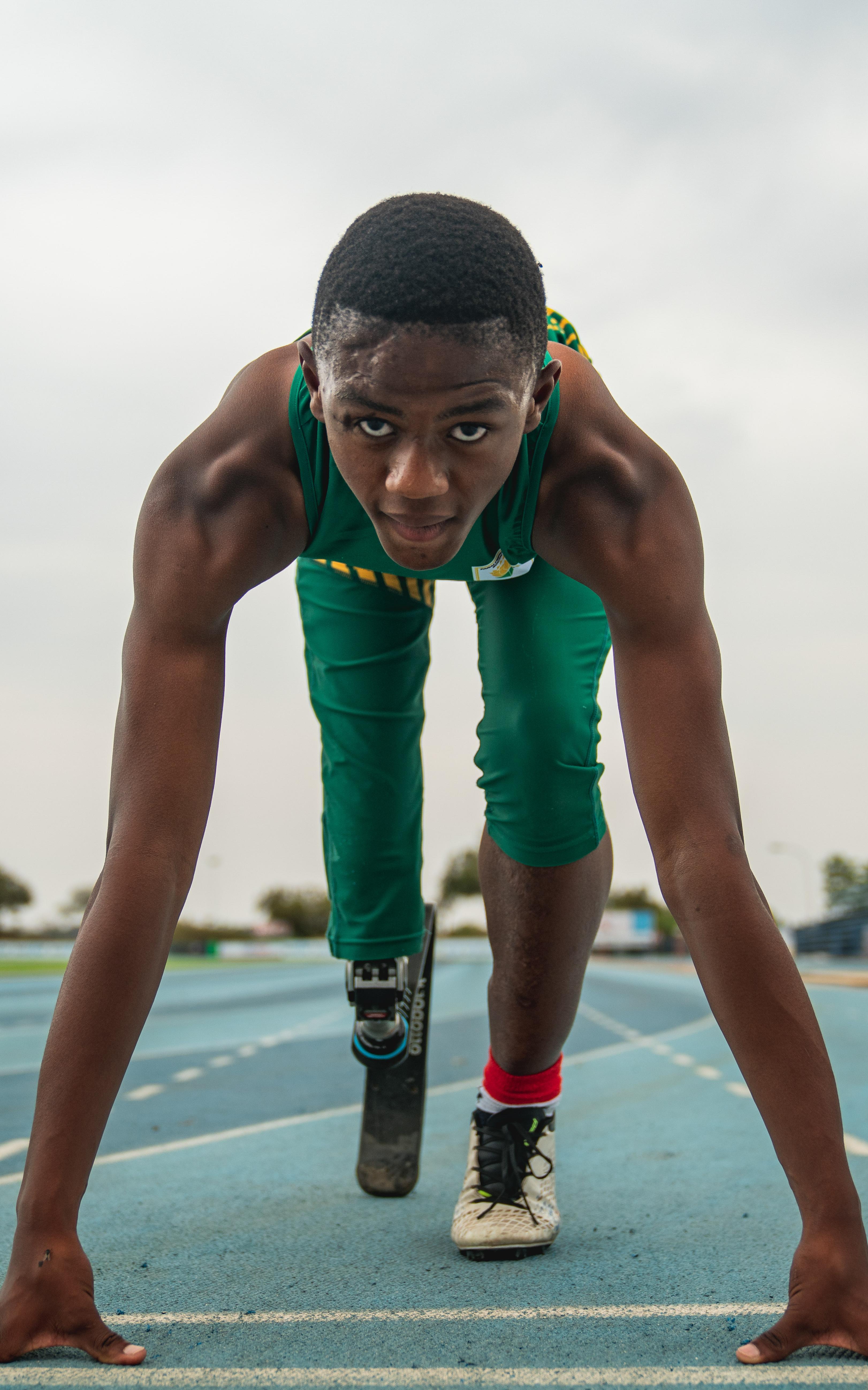 Young man with prosthetic leg getting ready to sprint
