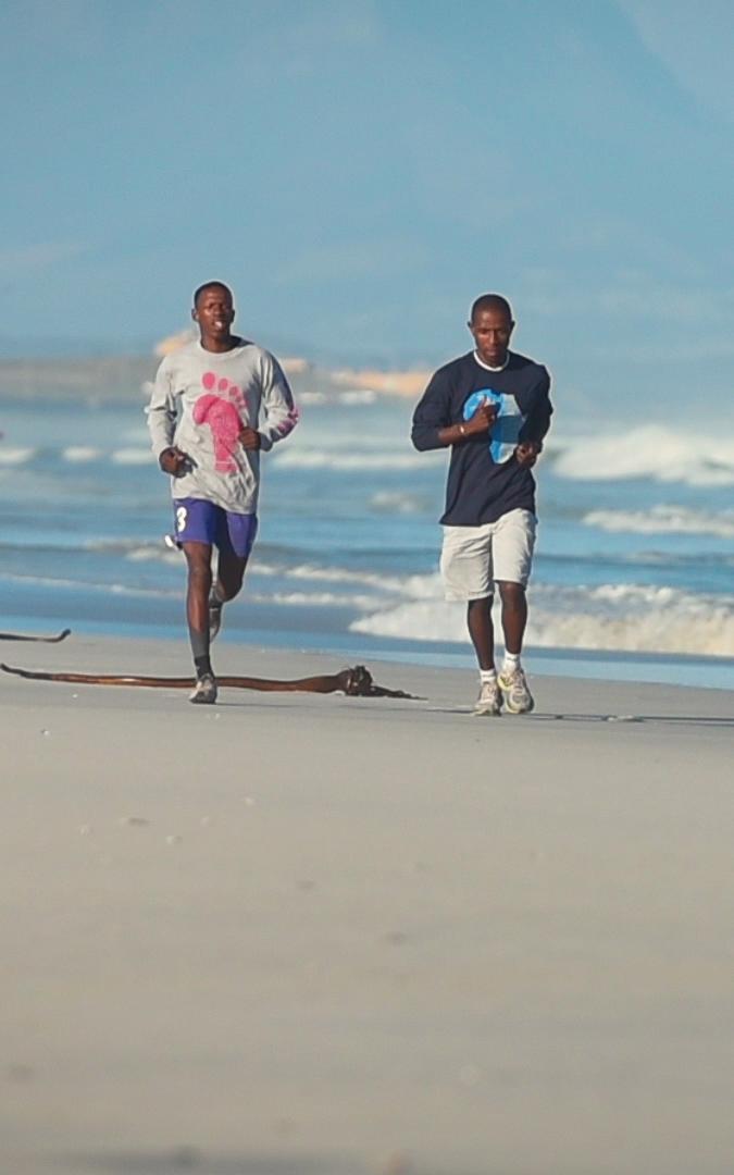 Two men running on the beach