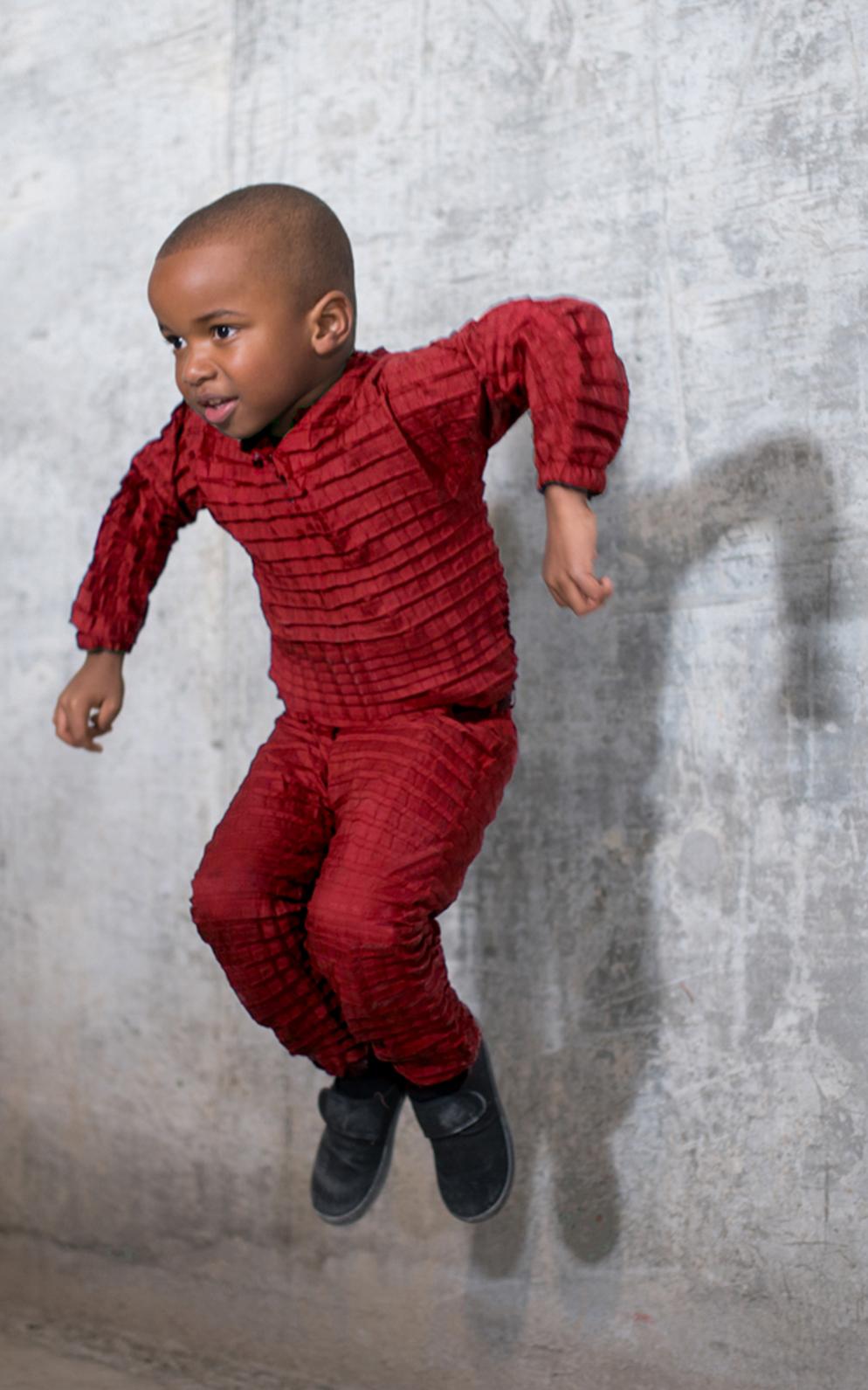 Beautiful News-Kid jumping with red pajamas on.